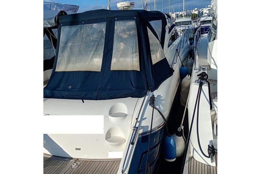 2002 Princess V50 yacht docked with blue canopy and fenders.