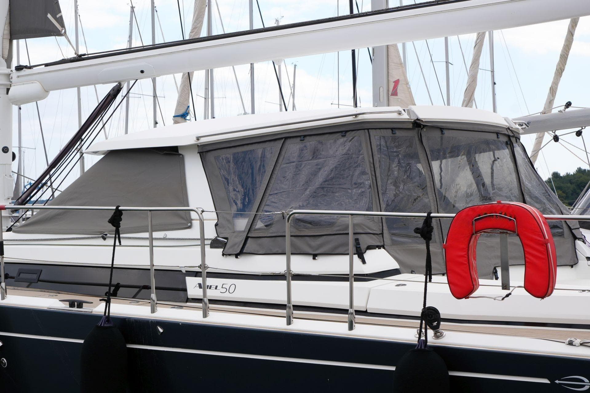 2017 Amel 50 yacht docked, featuring protective covers and a red life preserver.