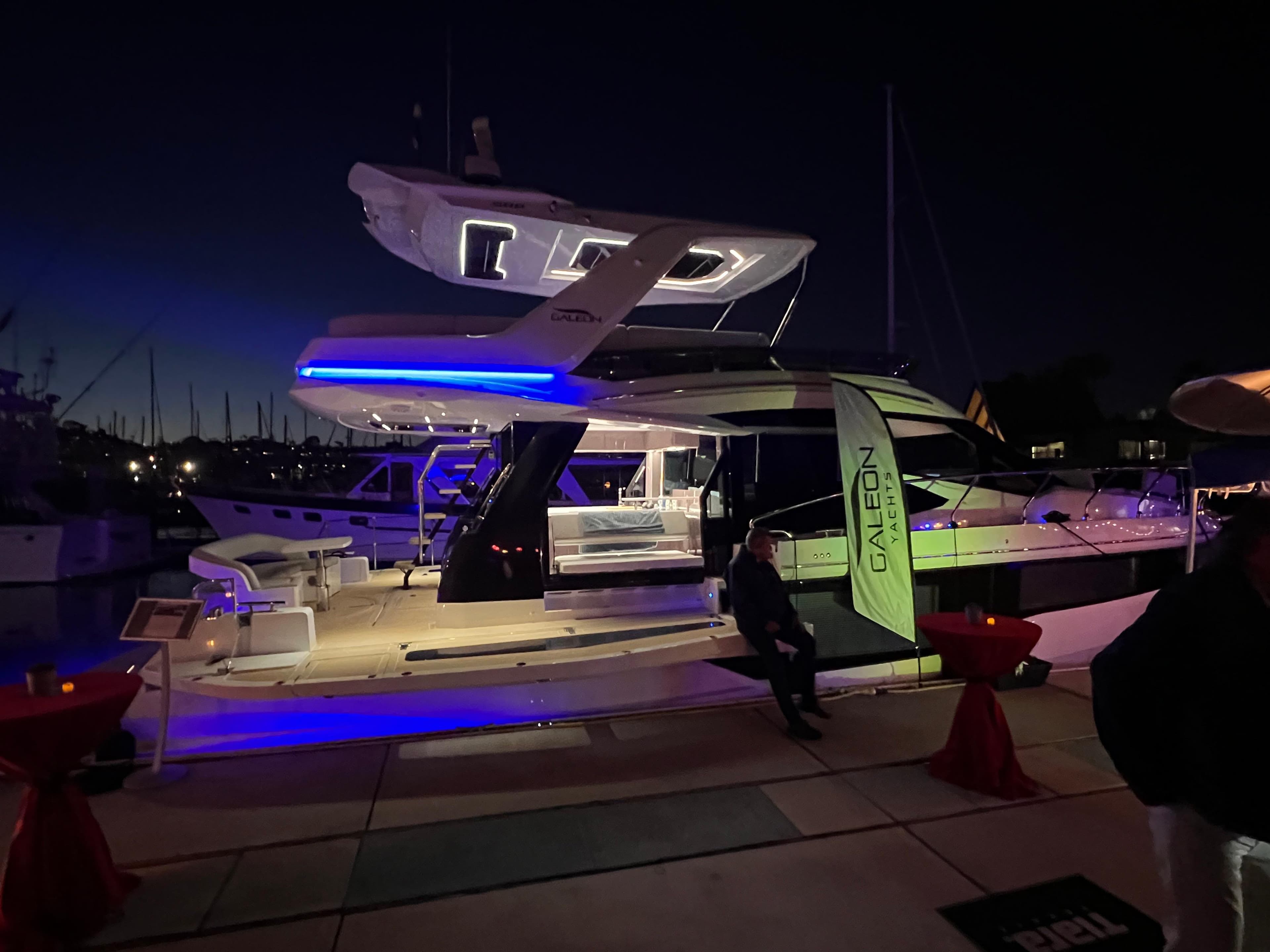 2025 Galeon 500 Fly yacht illuminated at night, docked with vibrant blue lighting.