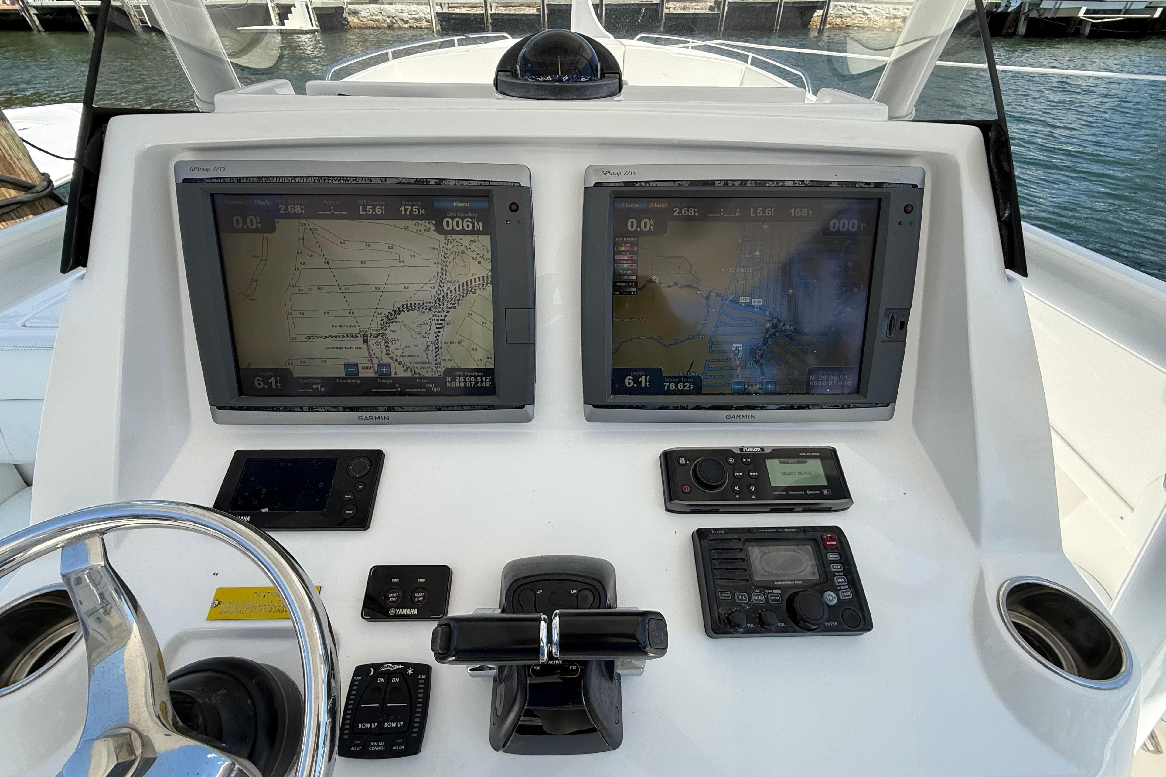 Control panel of a 2013 Intrepid 327 Cuddy boat with navigation screens and controls.