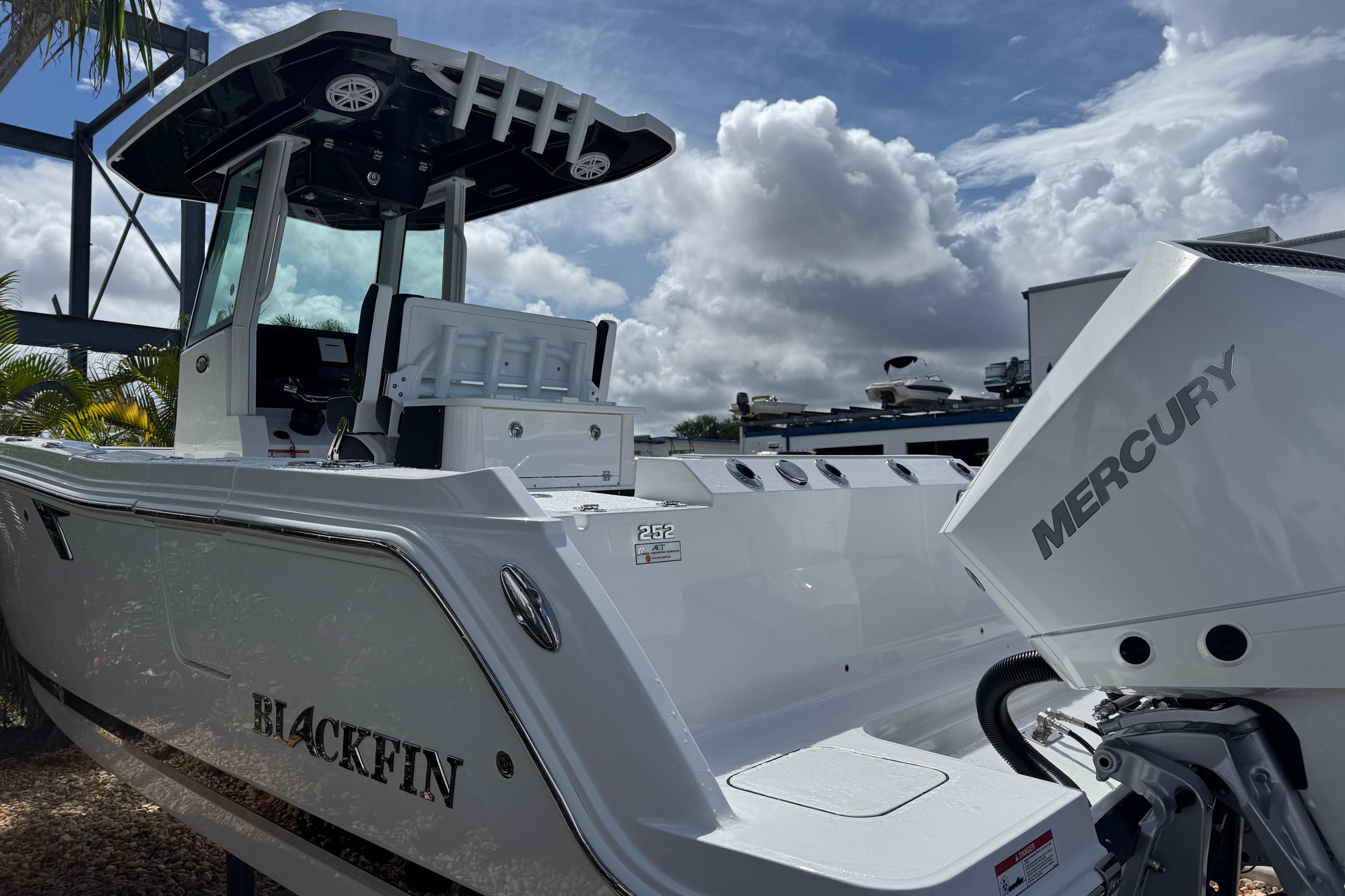 2025 Blackfin 252 CC boat with Mercury engine under cloudy sky.