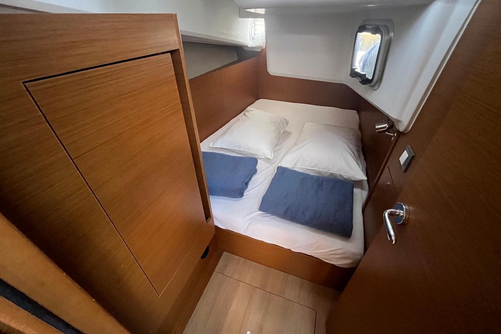 Cozy cabin interior of 2022 Jeanneau Sun Odyssey 410 sailboat with wooden finish.