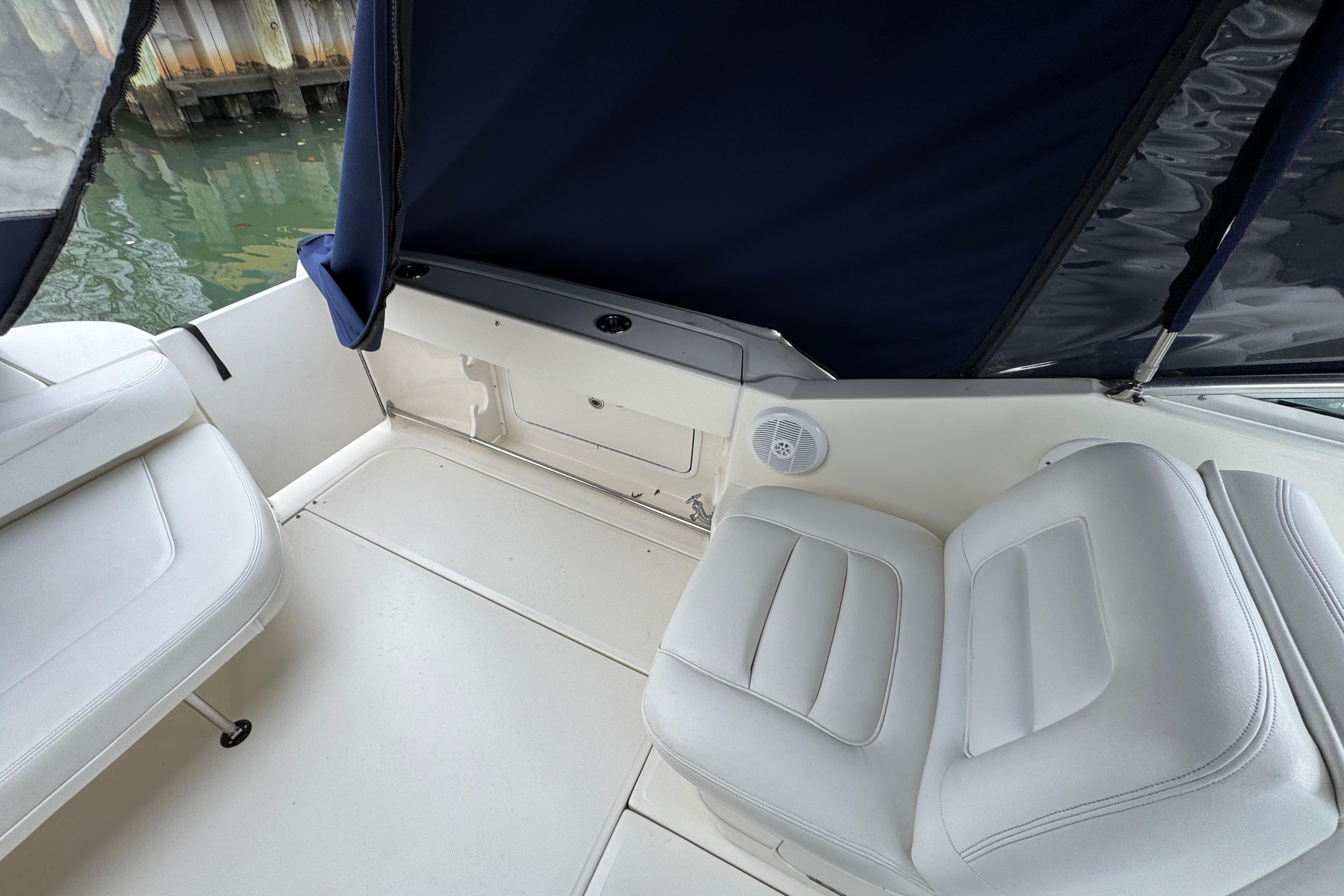 2007 Sea Ray 290 Amberjack boat interior with white seating and blue canopy.