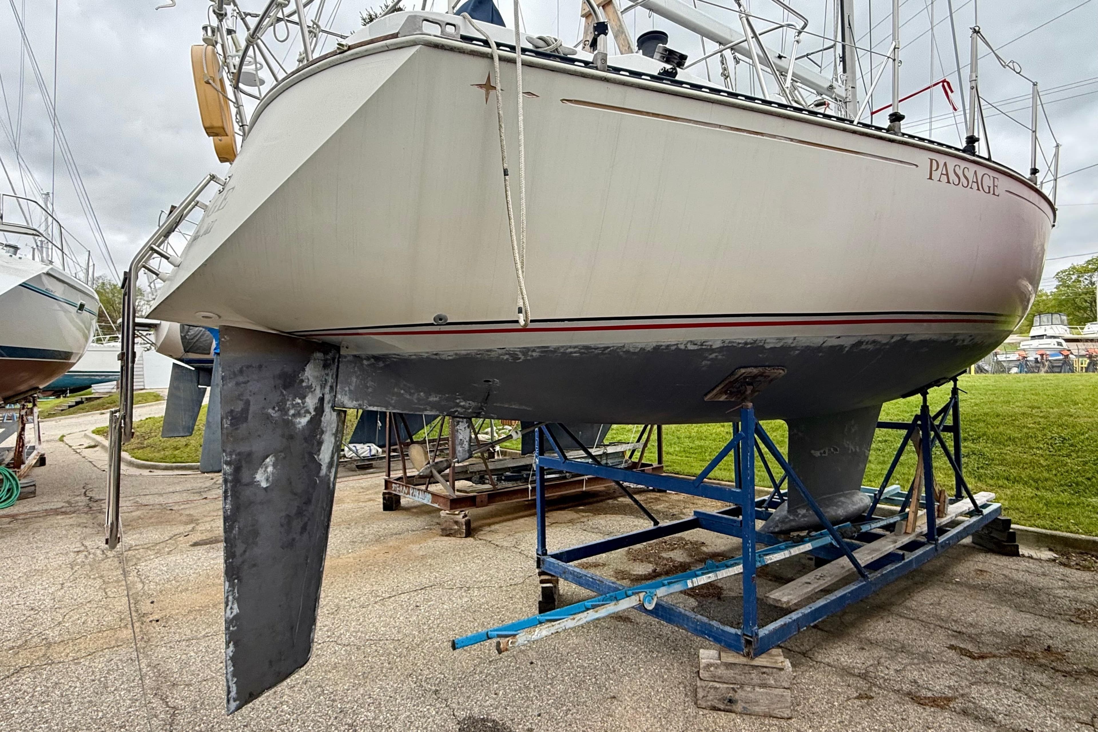 1983 C&C 34 sailboat on a stand, showing hull and keel in a boatyard.