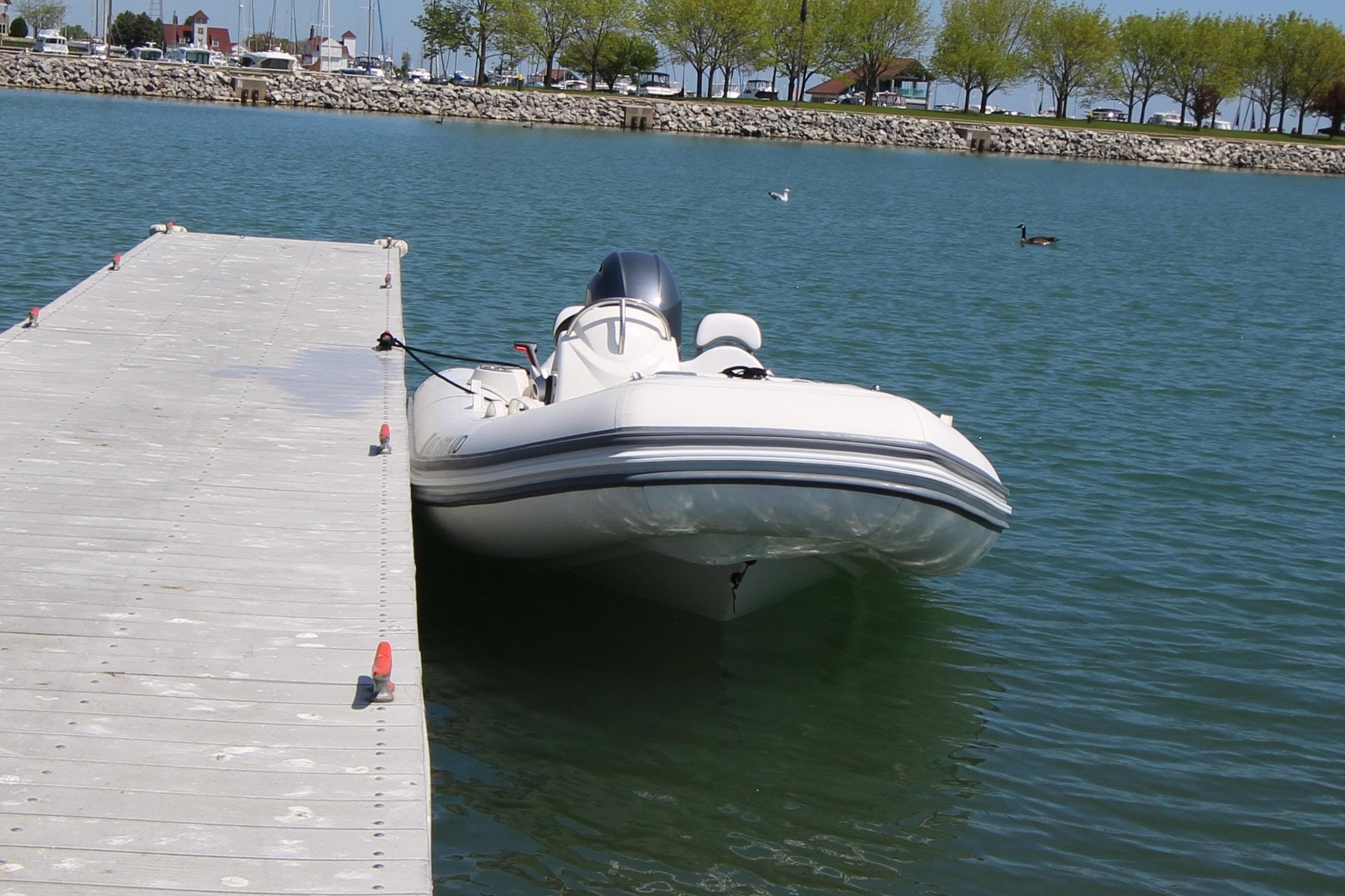 2023 Zodiac Yachtline 490 docked on calm water near a pier.