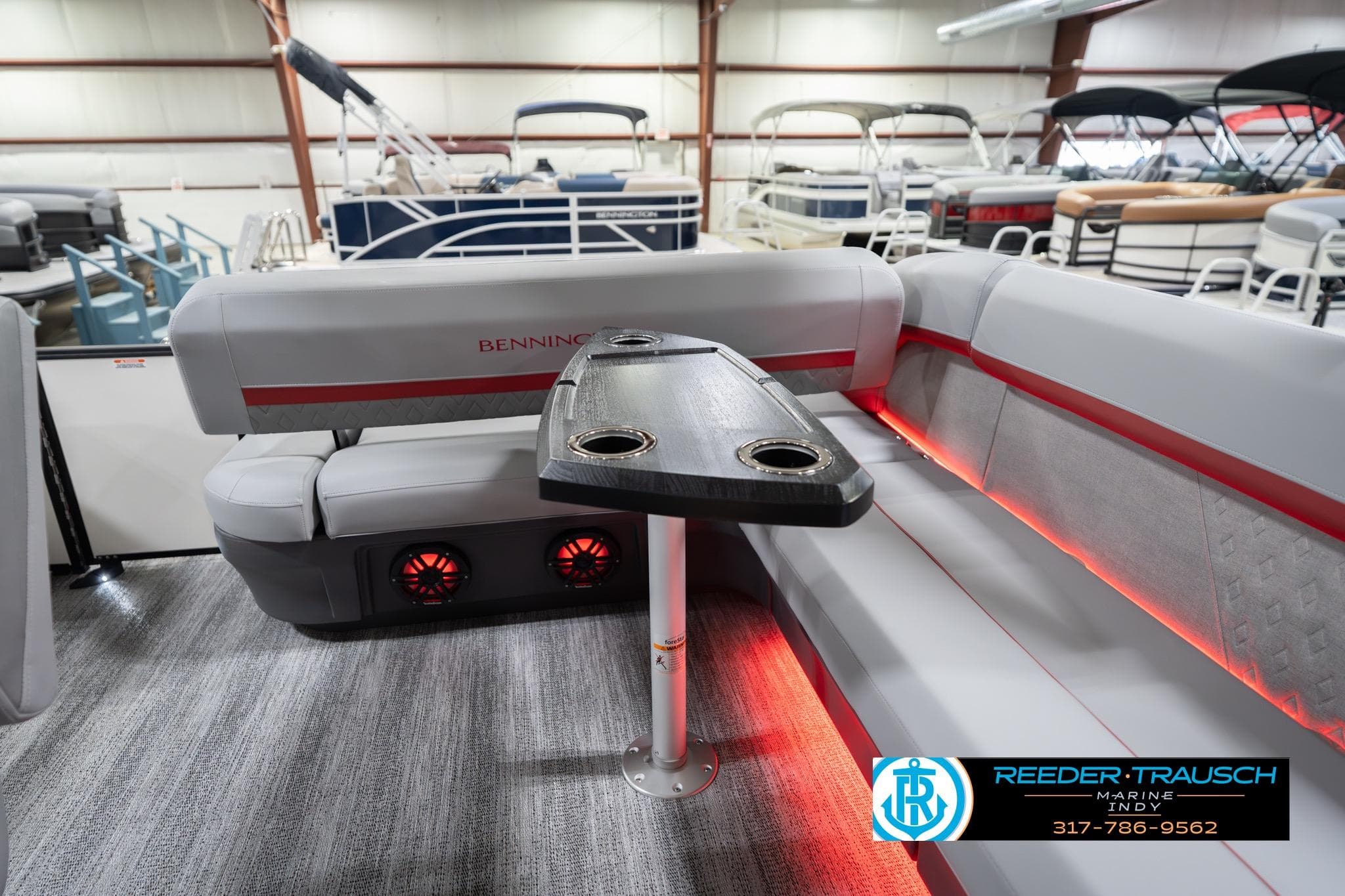 2026 Bennington 22 ML pontoon boat interior with seating and table, featuring ambient lighting.
