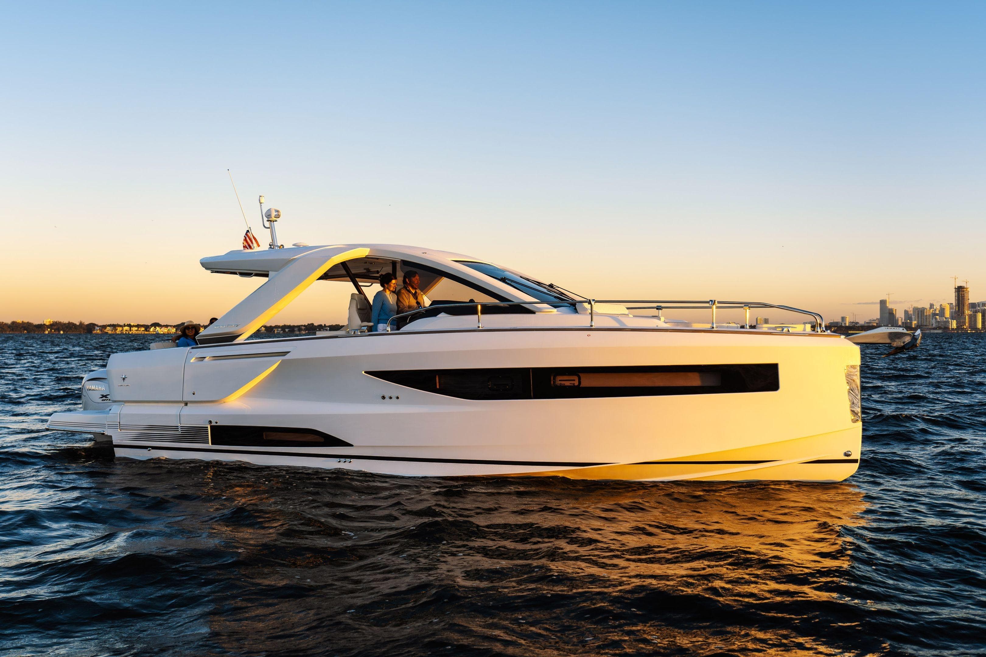 2026 Jeanneau DB/37 OB yacht cruising on water at sunset.