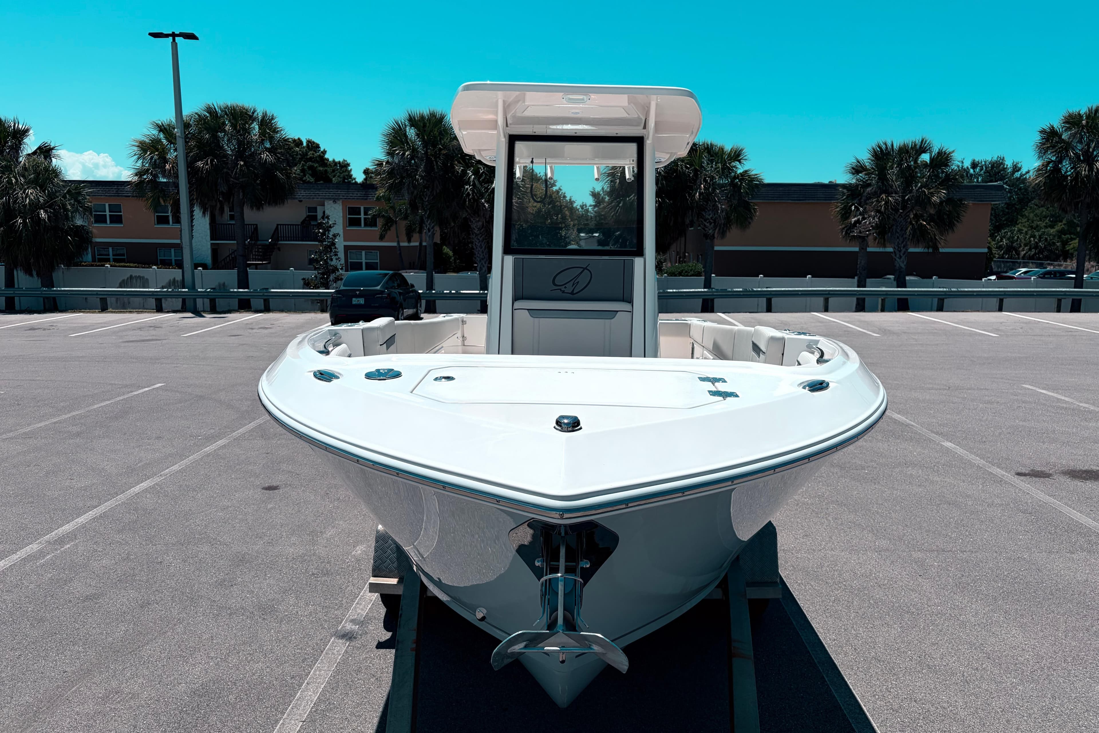2026 Sailfish 252 CC boat in parking lot, front view, clear sky background.