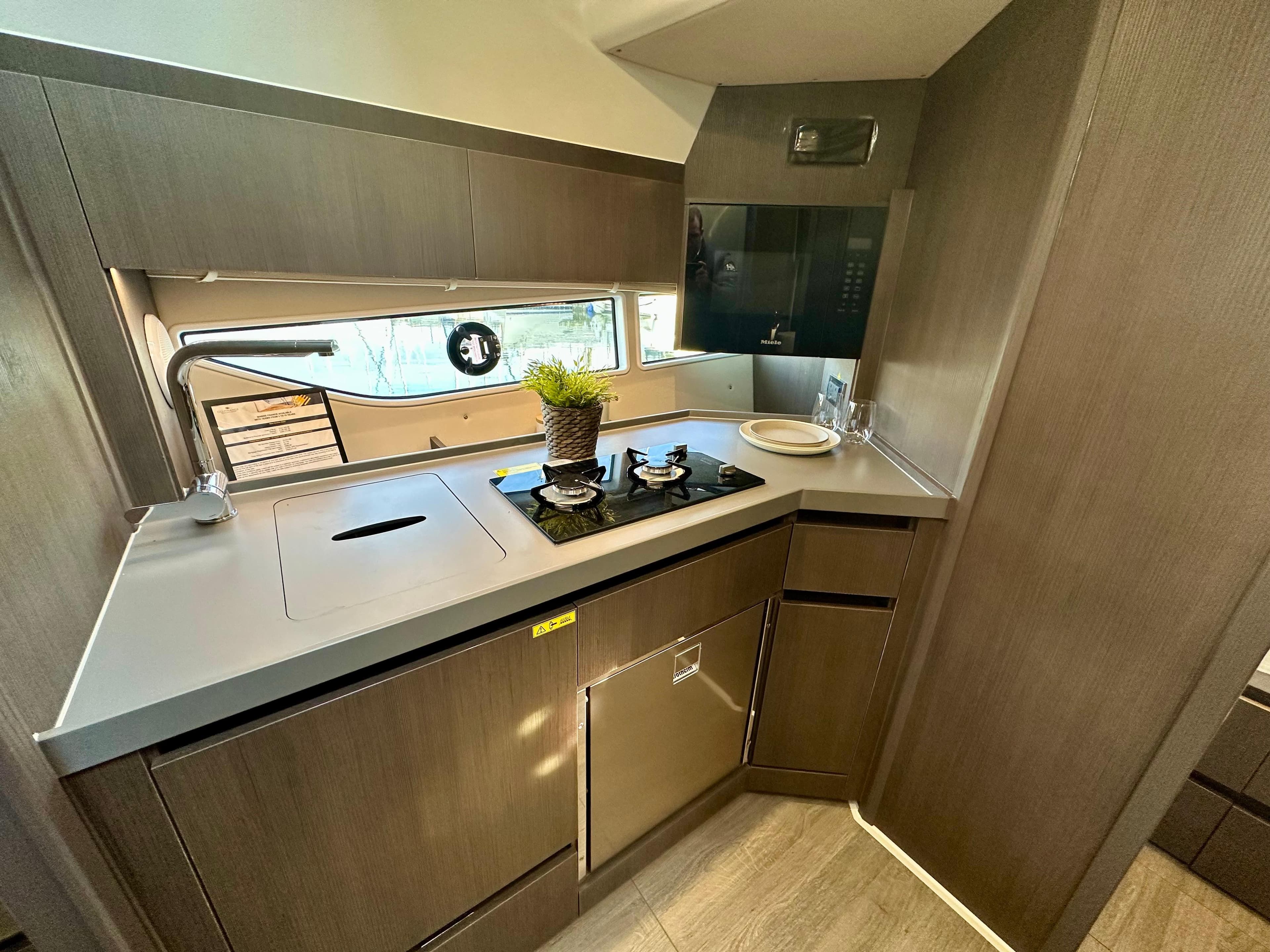 Modern kitchen interior of 2025 Sealine S335 yacht with sleek cabinetry and appliances.