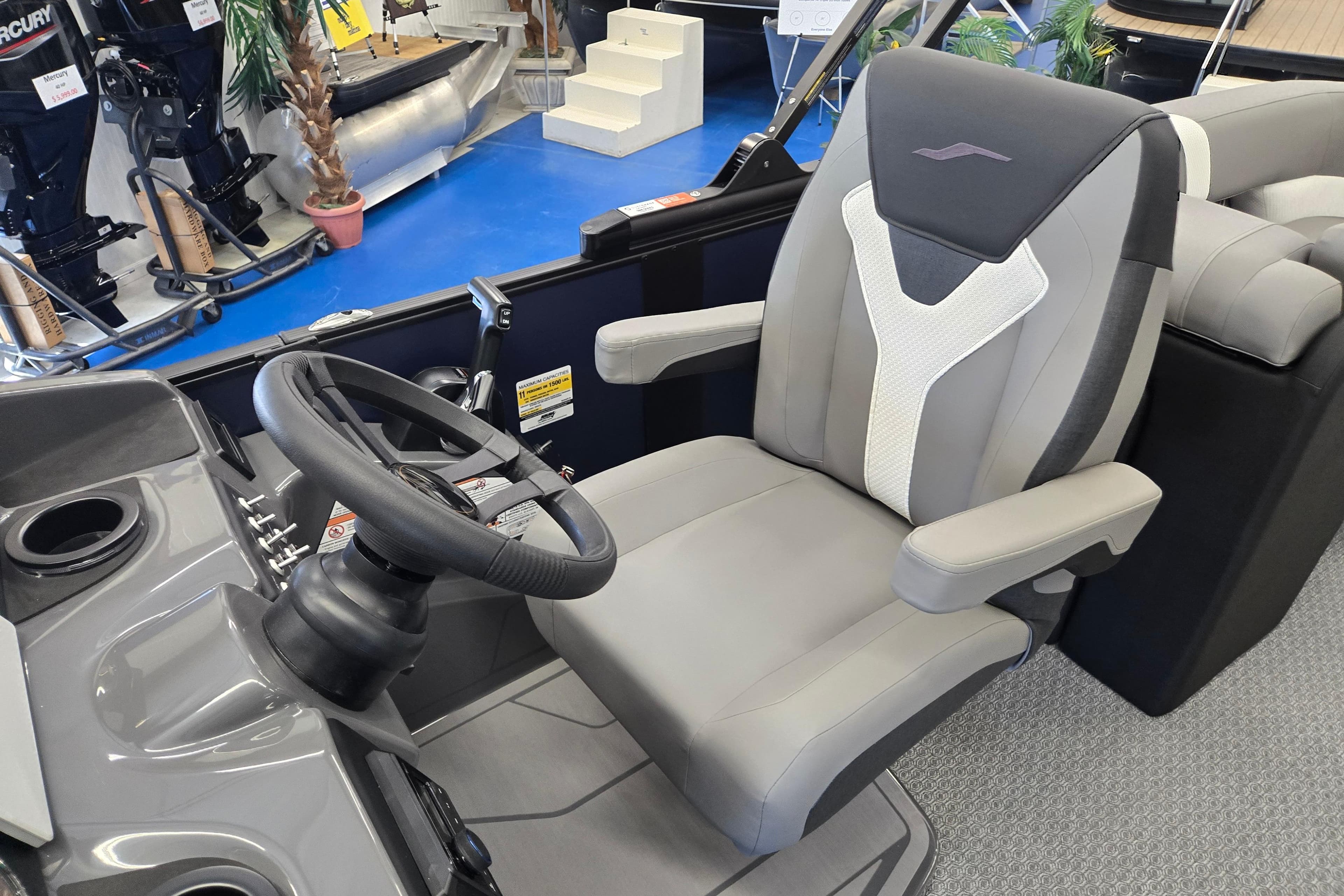 Captain's chair and steering wheel of 2026 Evotti 521QL boat in showroom.