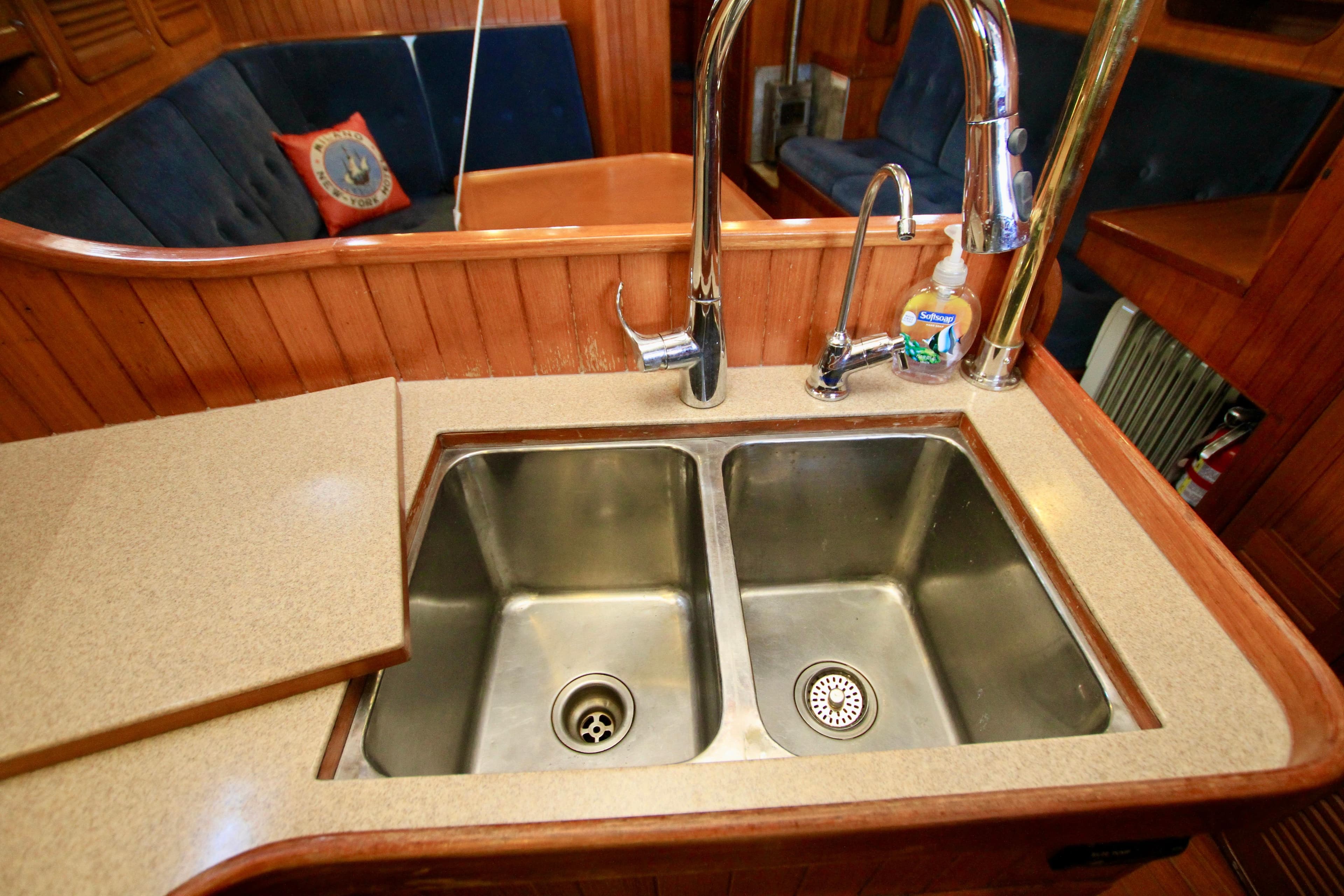 Double sink in 1981 Ta-Shing Panda 40 yacht galley with wooden cabinetry.