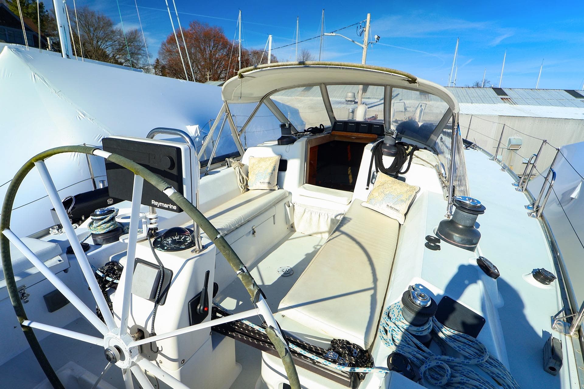 2004 J Boats J/46 sailboat cockpit with steering wheel and seating under blue sky.