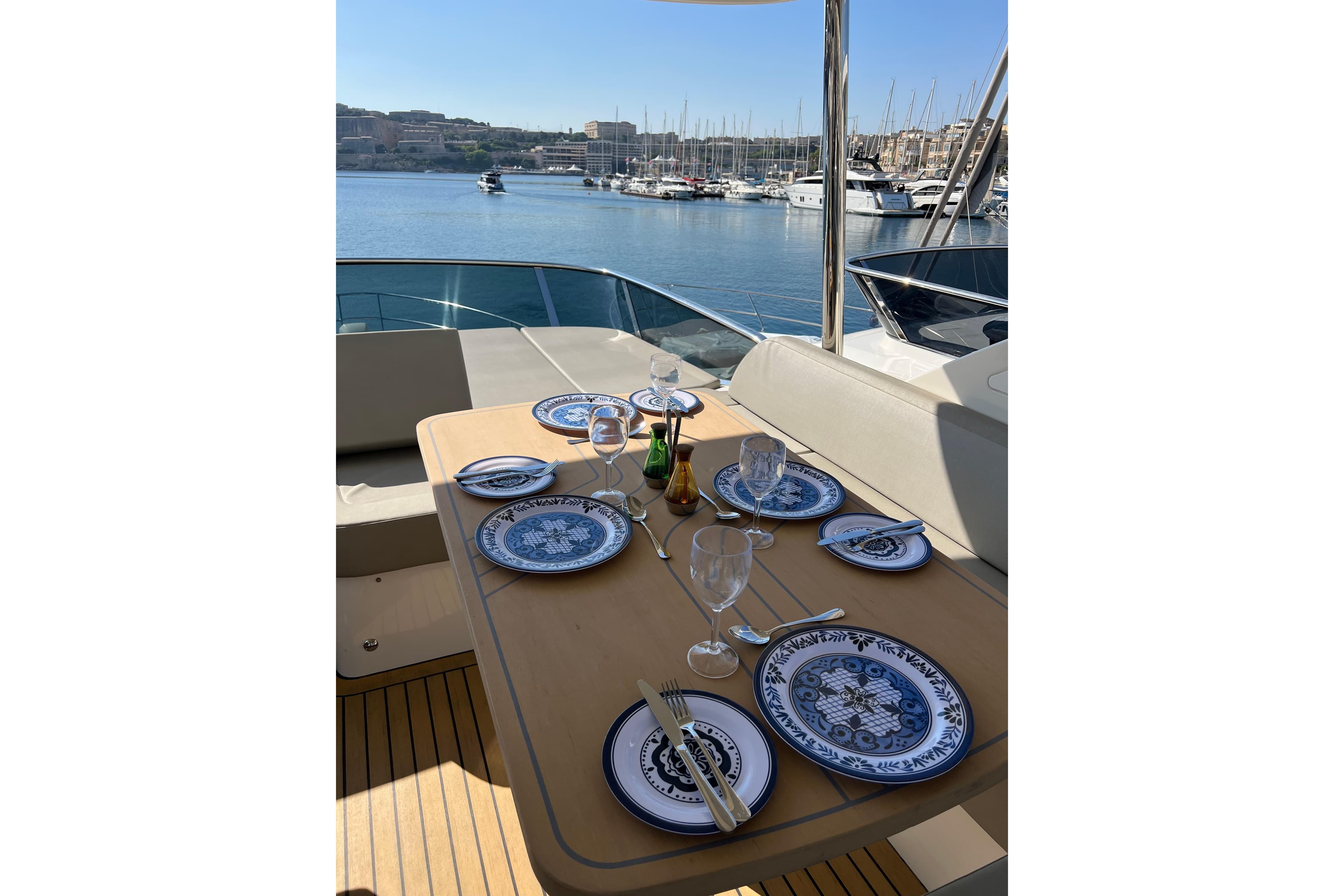 Elegant dining setup on 2023 Absolute 52 Fly yacht, overlooking serene marina.