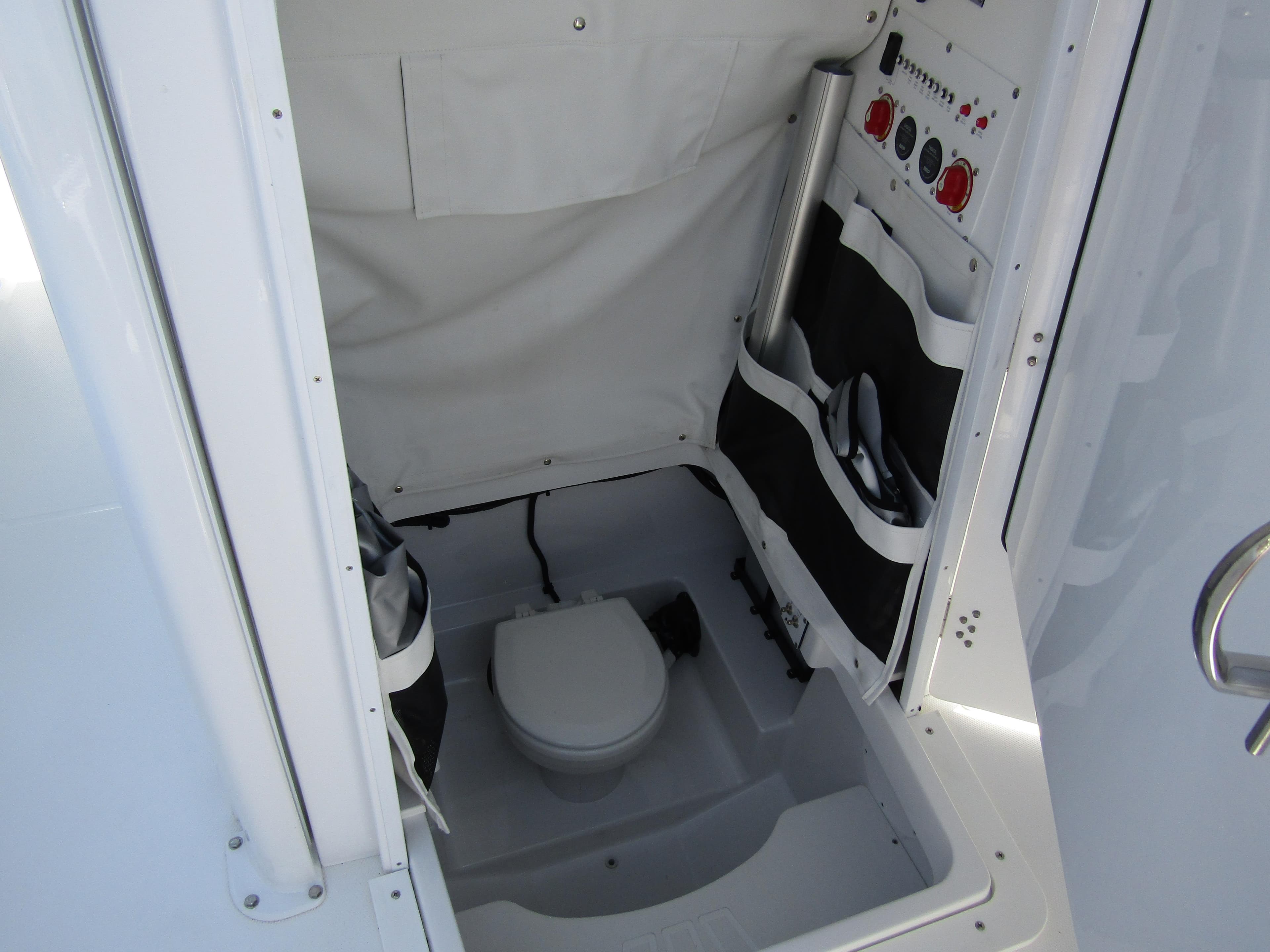 2024 Wellcraft 243 Fisherman boat interior with compact marine toilet and storage compartments.