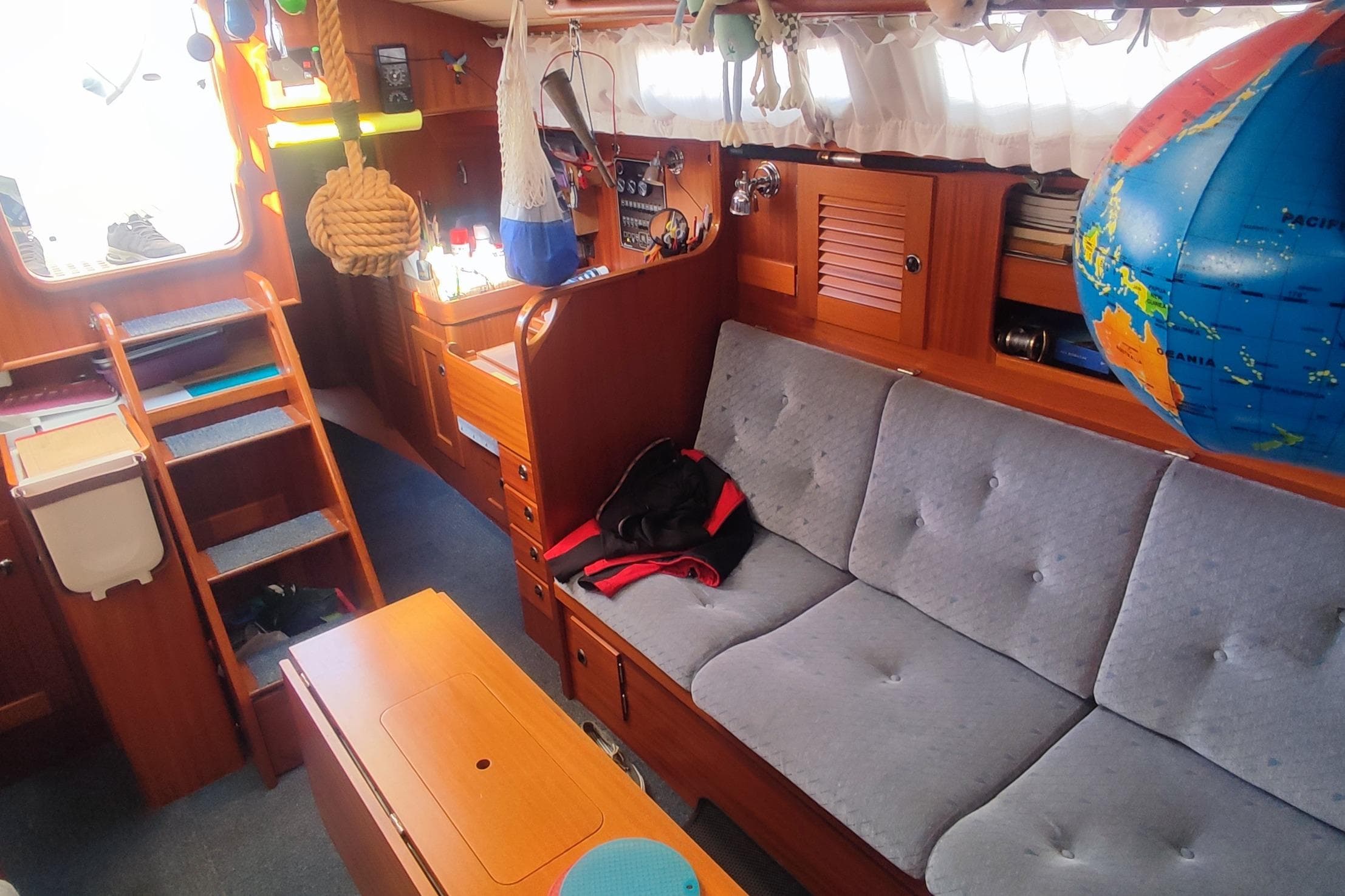 Interior of 2002 Hallberg-Rassy 36 MKII sailboat with cozy seating and nautical decor.