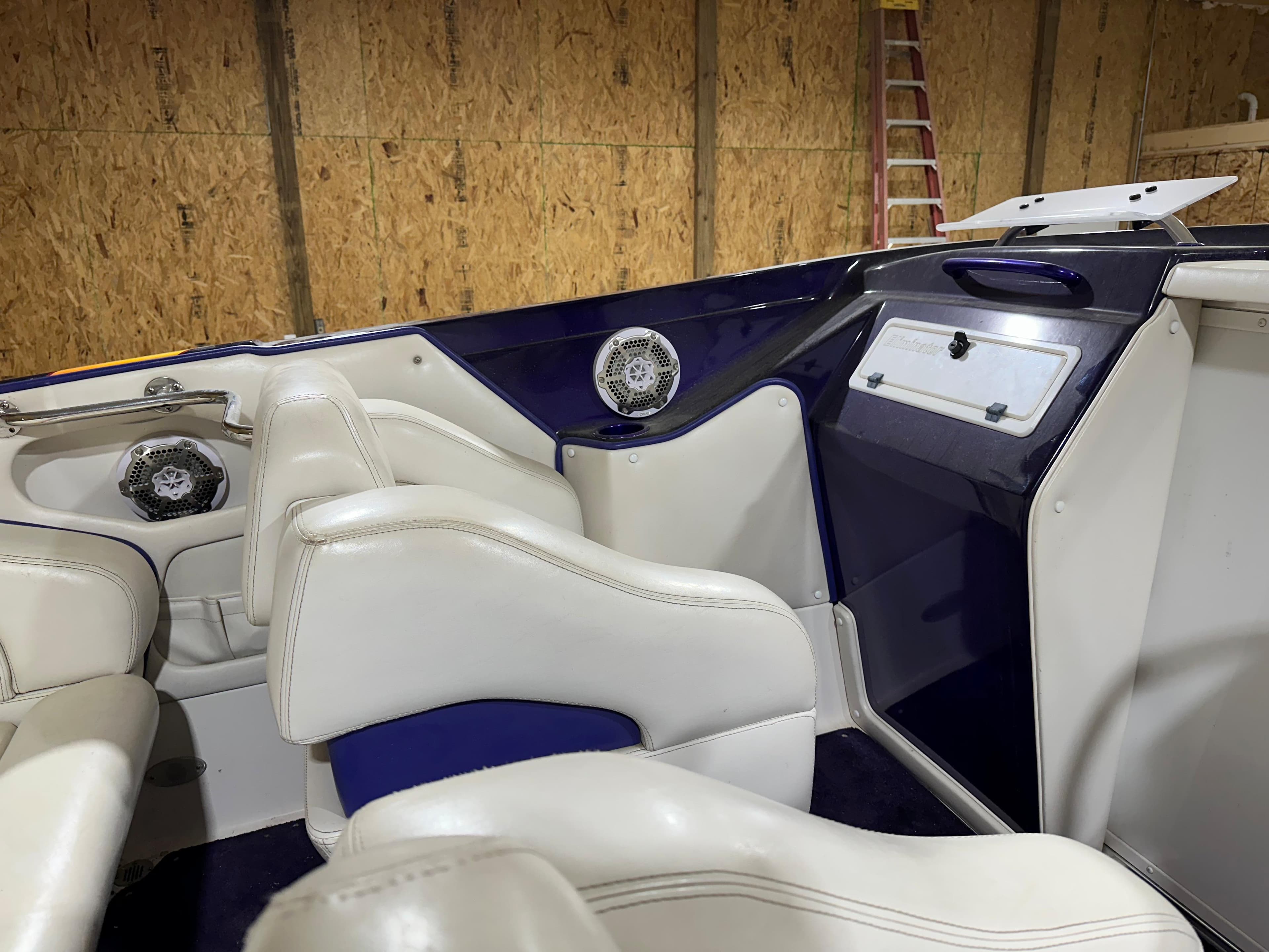 2005 Eliminator 260 Eagle XP boat interior with white seats and blue accents.