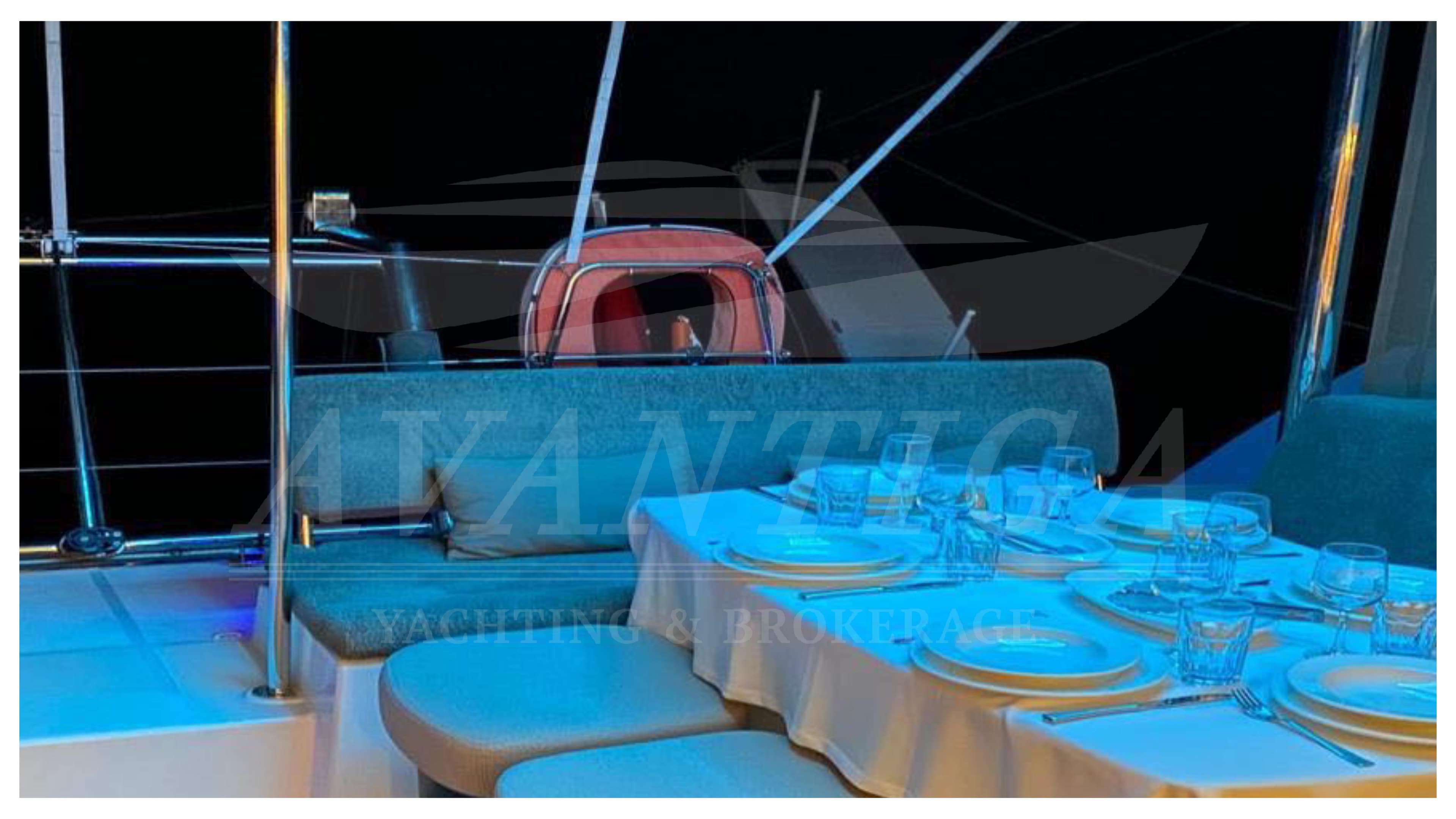 Elegant dining setup on a 2015 Lagoon 450 F yacht at night.