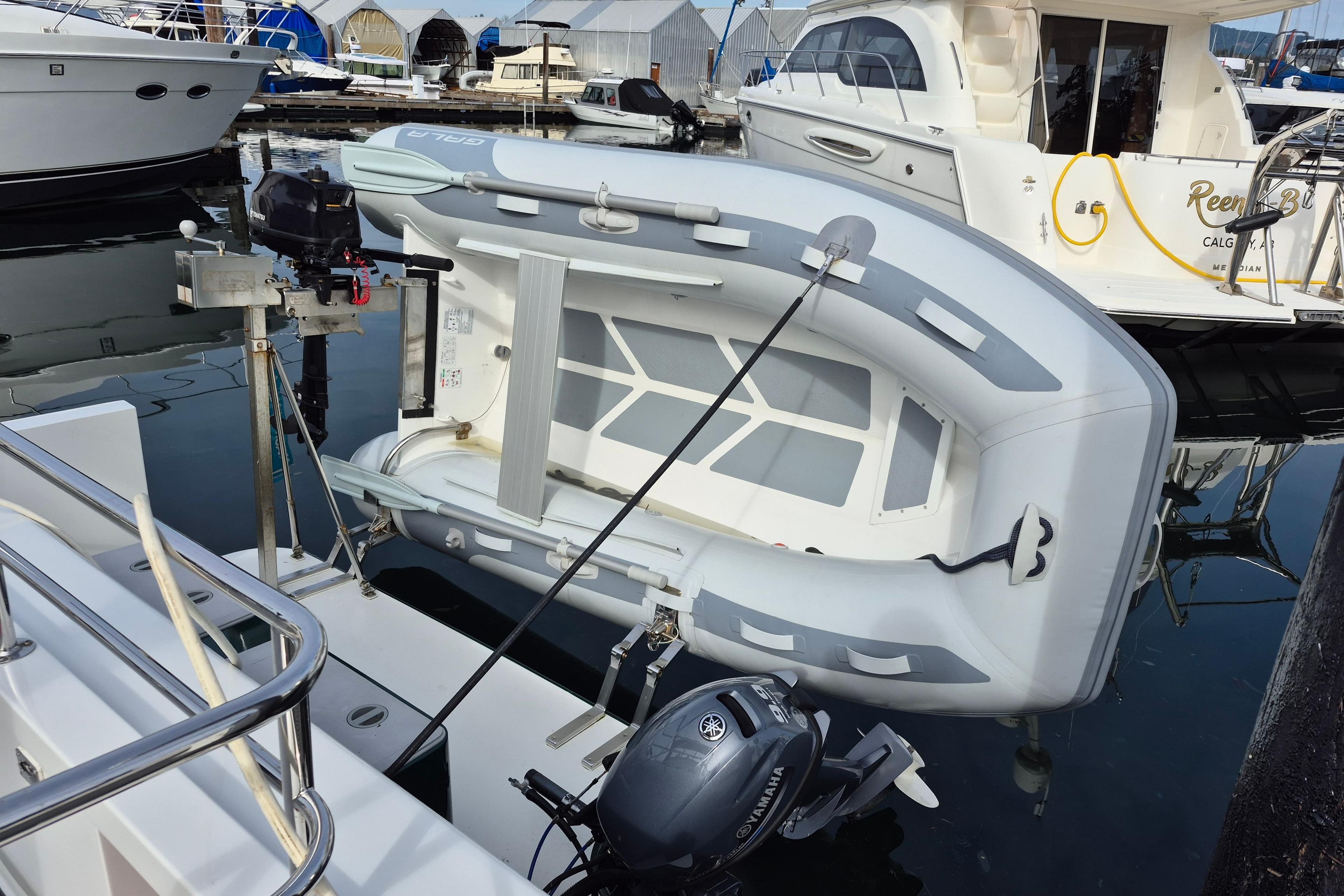 Inflatable dinghy with Yamaha motor docked beside Coastal Craft 300 Cruiser, 2004 model.