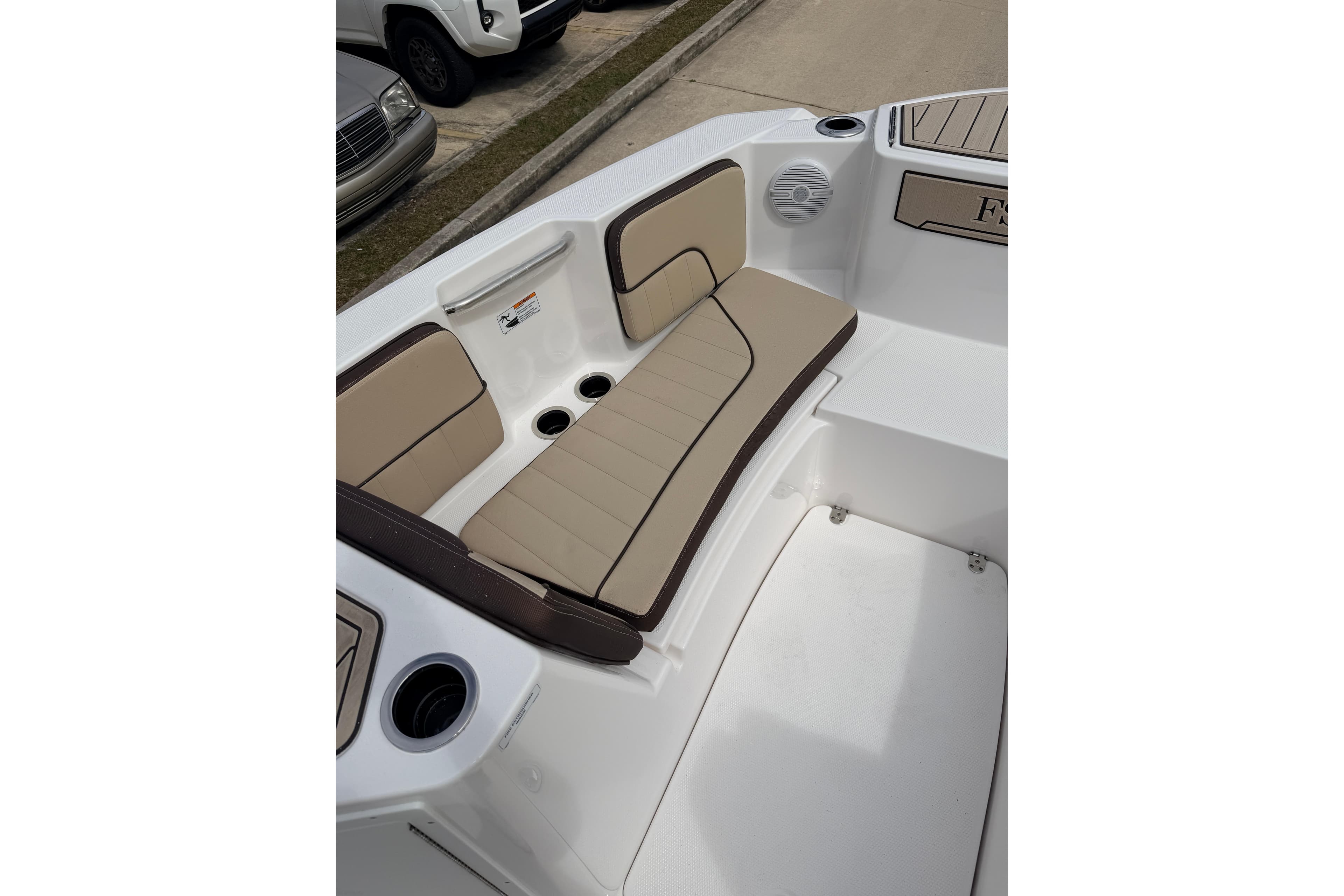2026 Yamaha Boats 222 FSH Sport interior seating with beige cushions and cup holders.