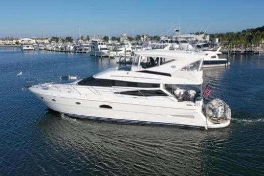 2005 Neptunus 56 Flybridge yacht cruising in a marina, surrounded by other boats.