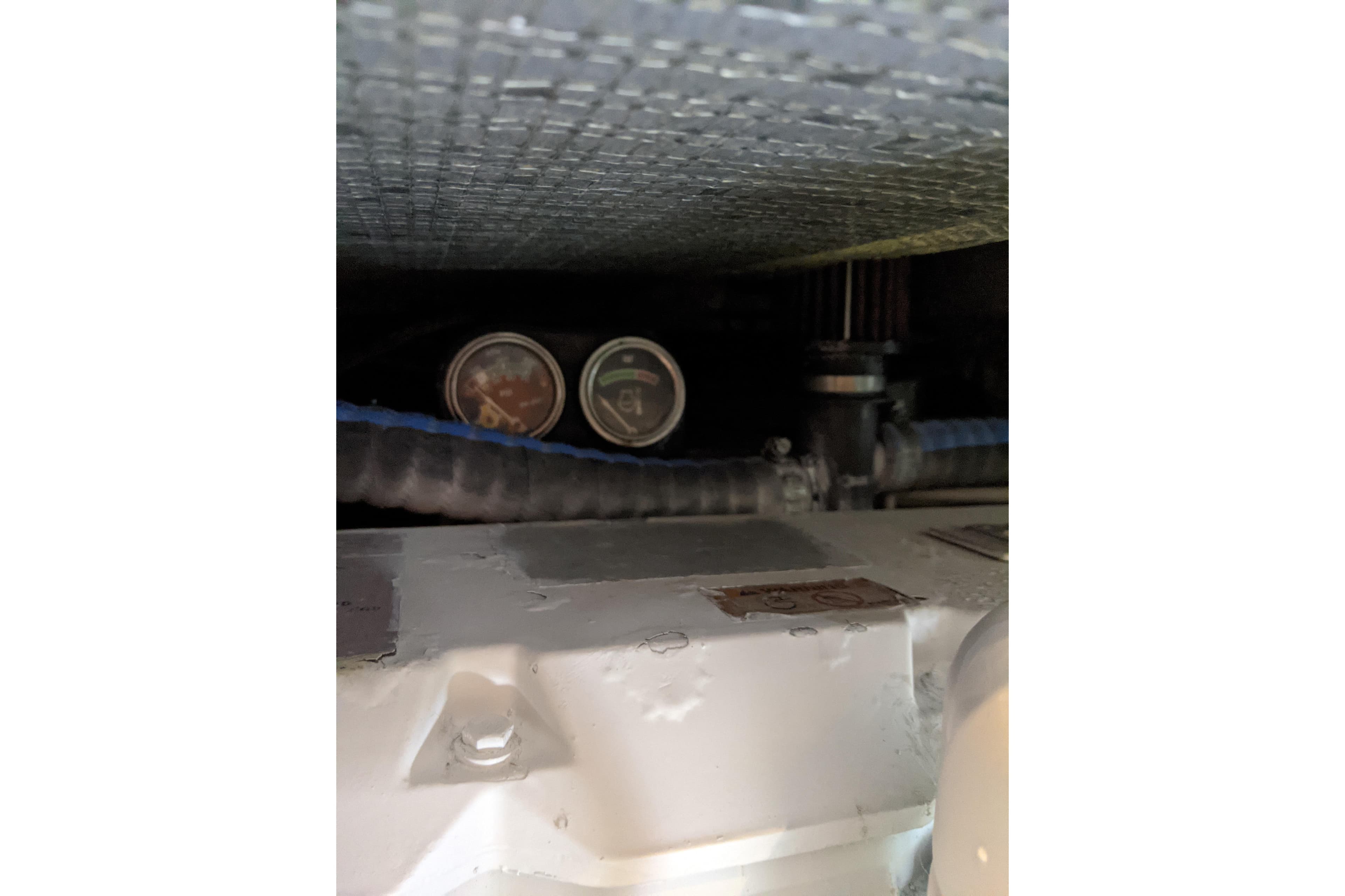 Engine compartment of a 1996 Sea Ray 420 Aft Cabin with visible gauges and hoses.