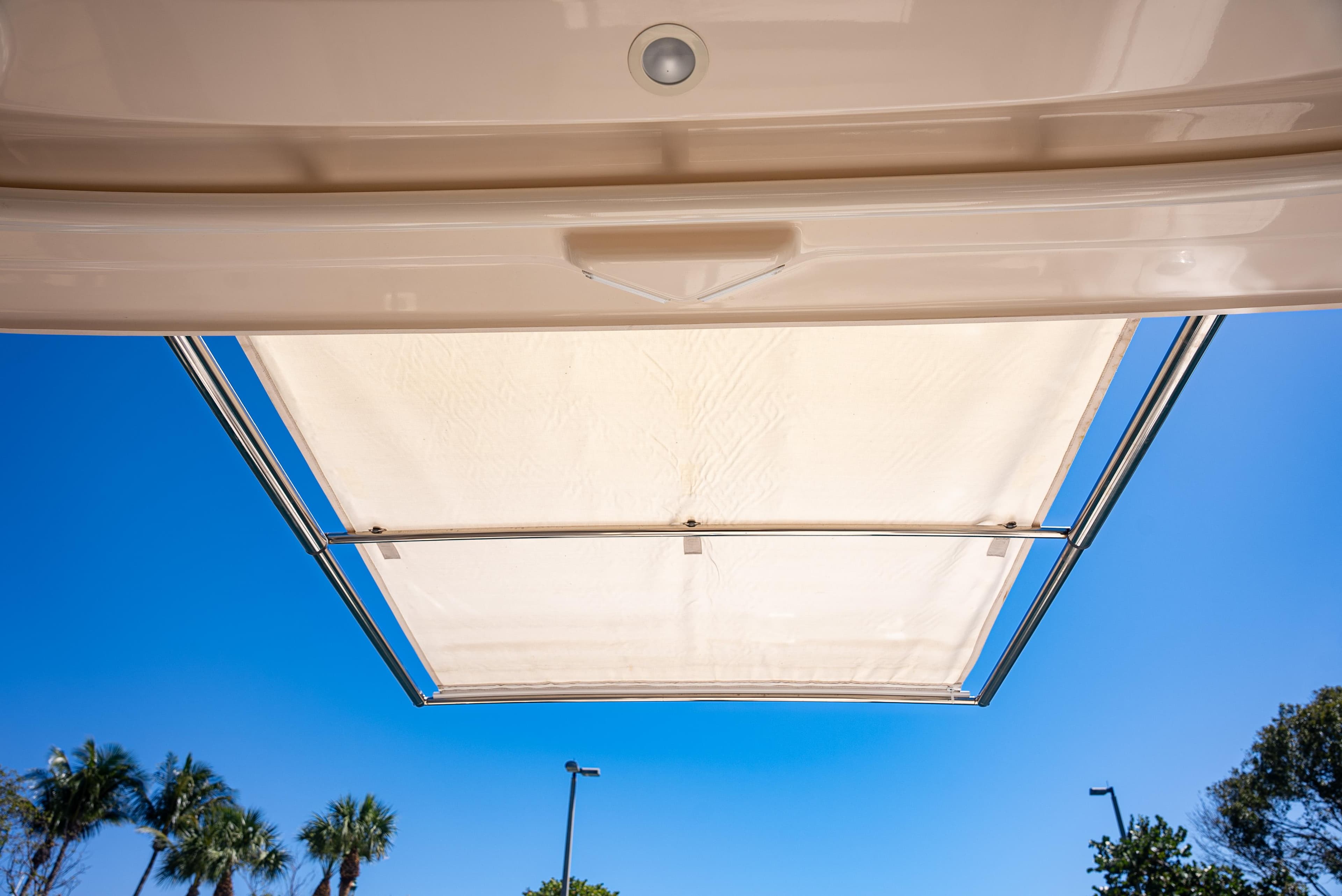 2020 Grady-White Freedom 285 boat canopy against clear blue sky and palm trees.