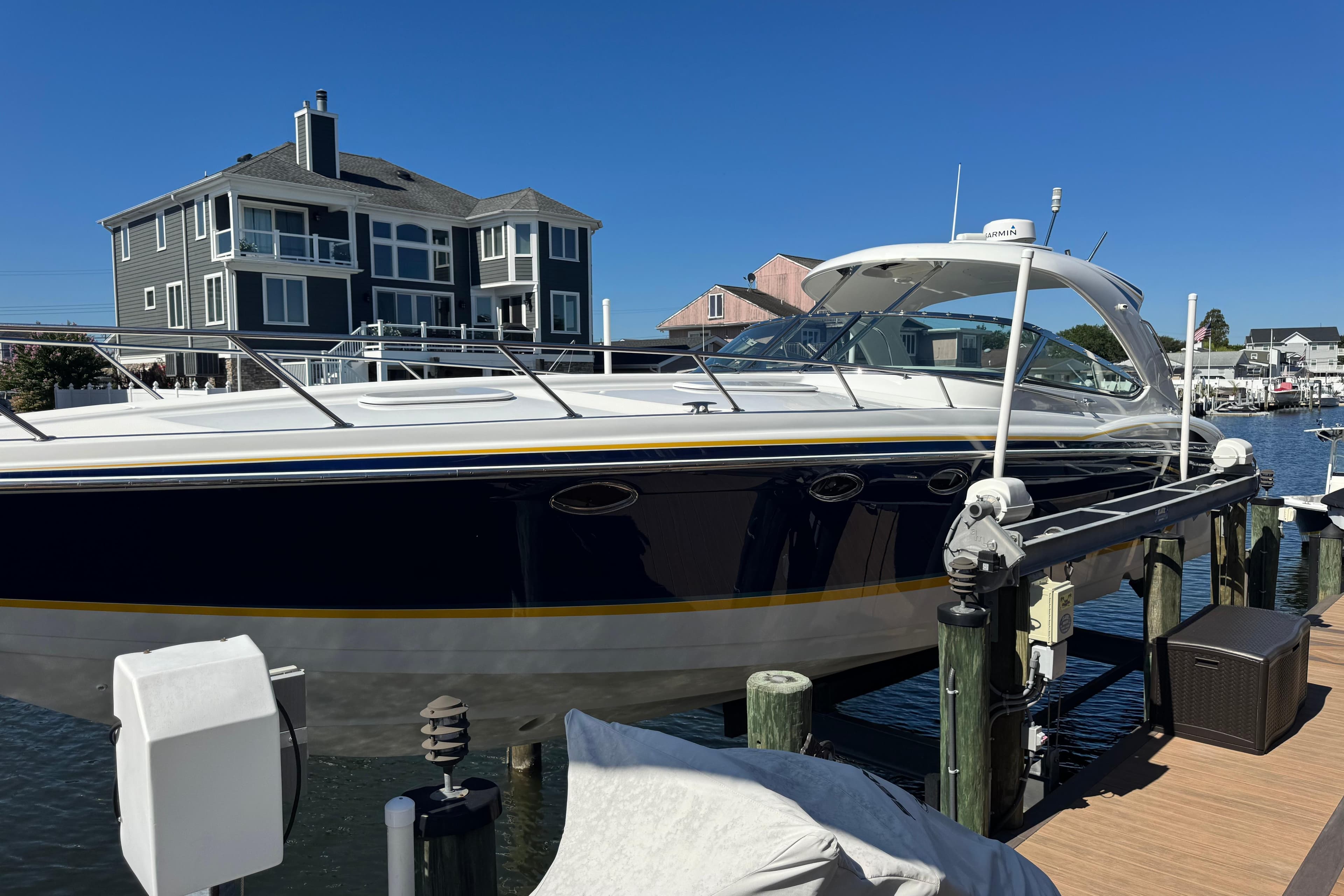 2006 Formula 400 Super Sport boat docked near waterfront homes.