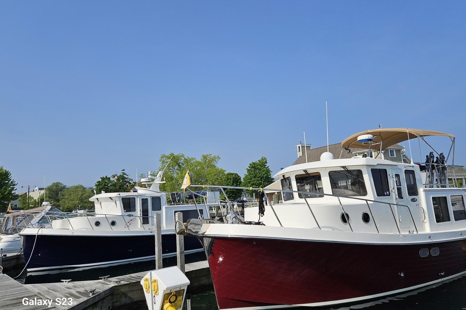 2006 American Tug 34 Pilothouse Trawler docked at marina under clear blue sky.