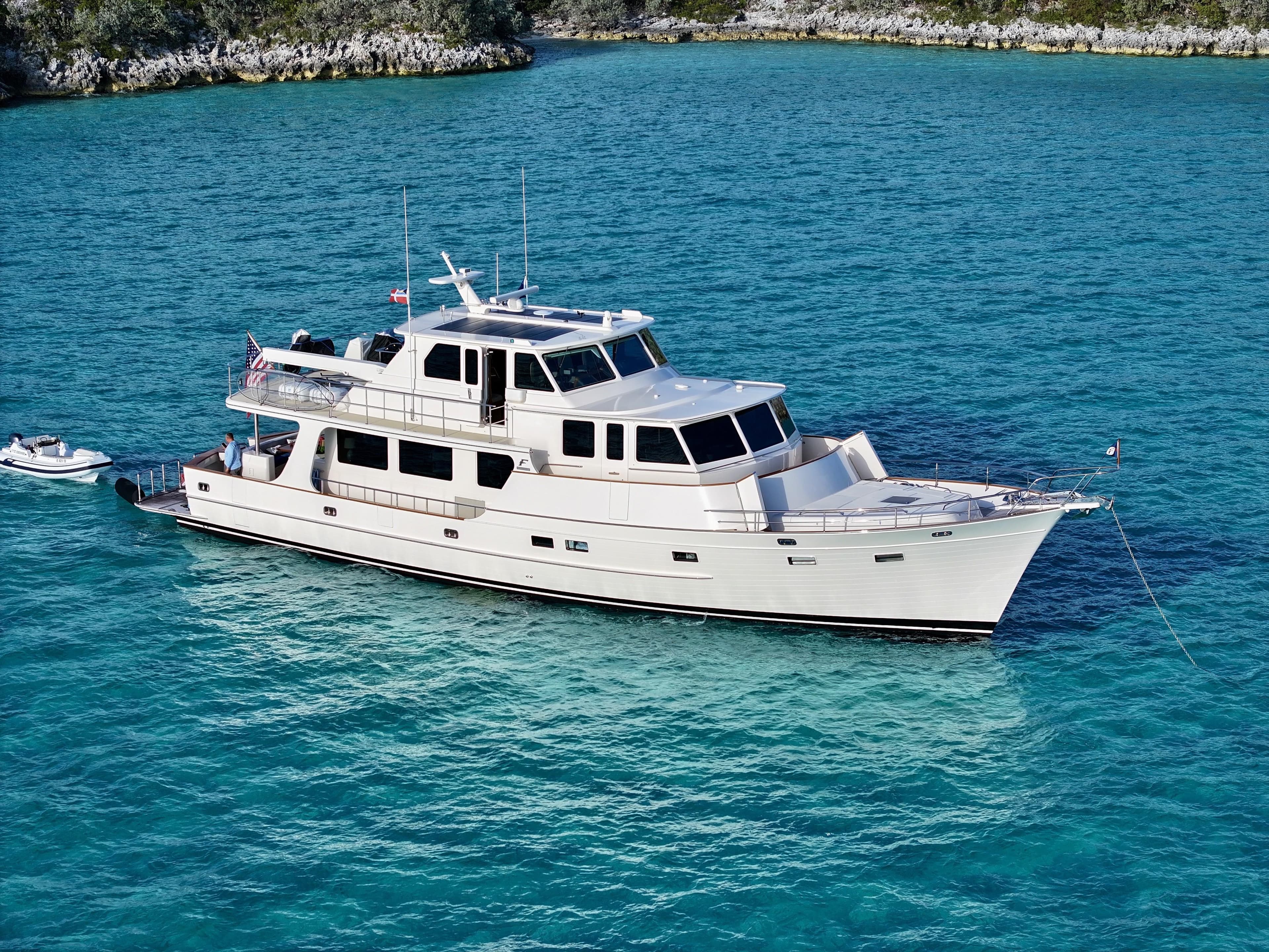 Luxurious 2027 Fleming 85 yacht cruising in clear turquoise waters.
