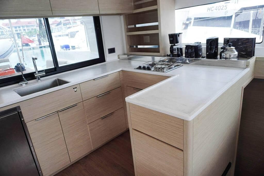Modern kitchen interior of 2023 Lagoon 46 yacht with sleek countertops and appliances.