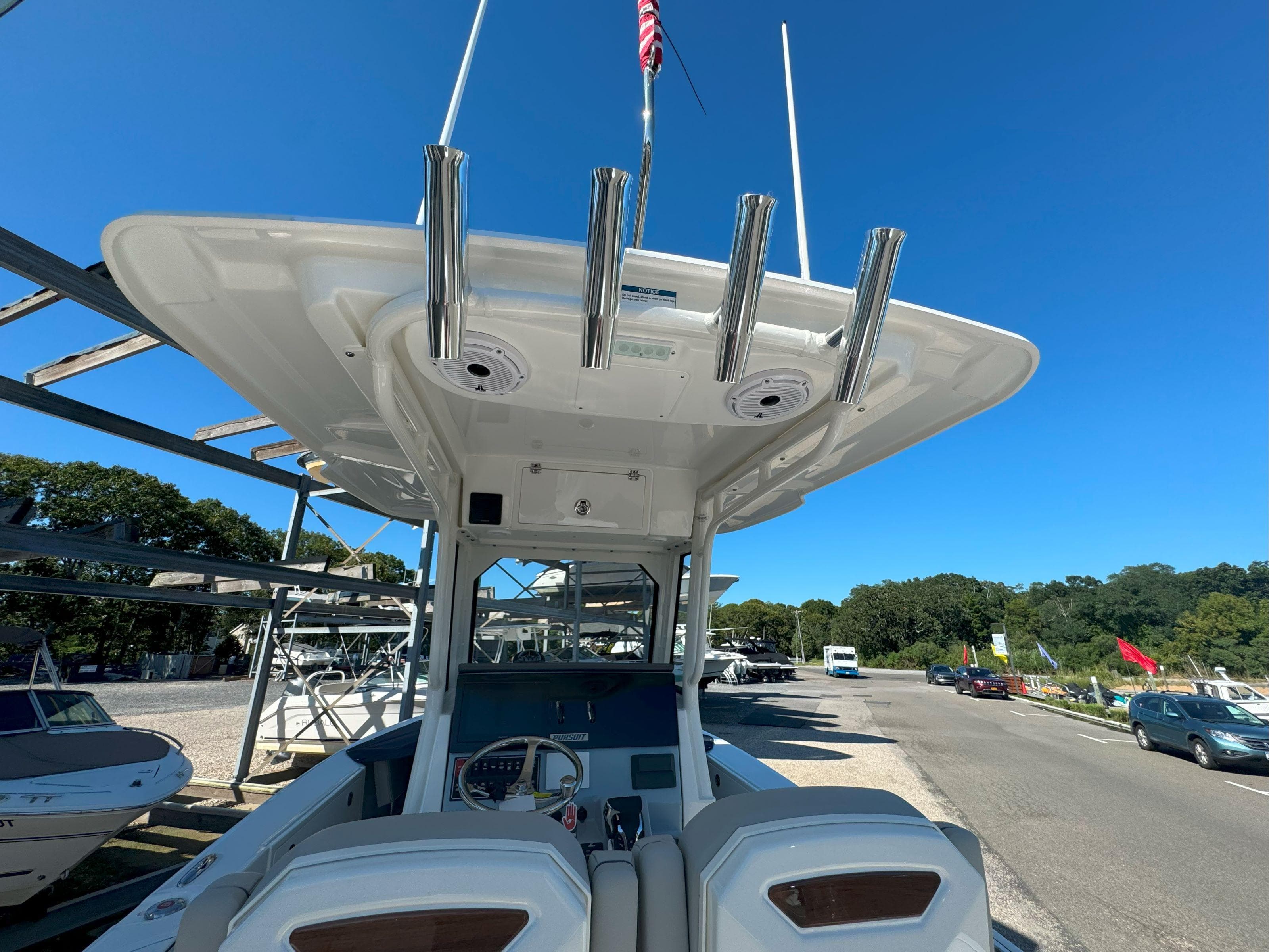 2025 Pursuit S 248 boat with T-top and rod holders, parked outdoors.