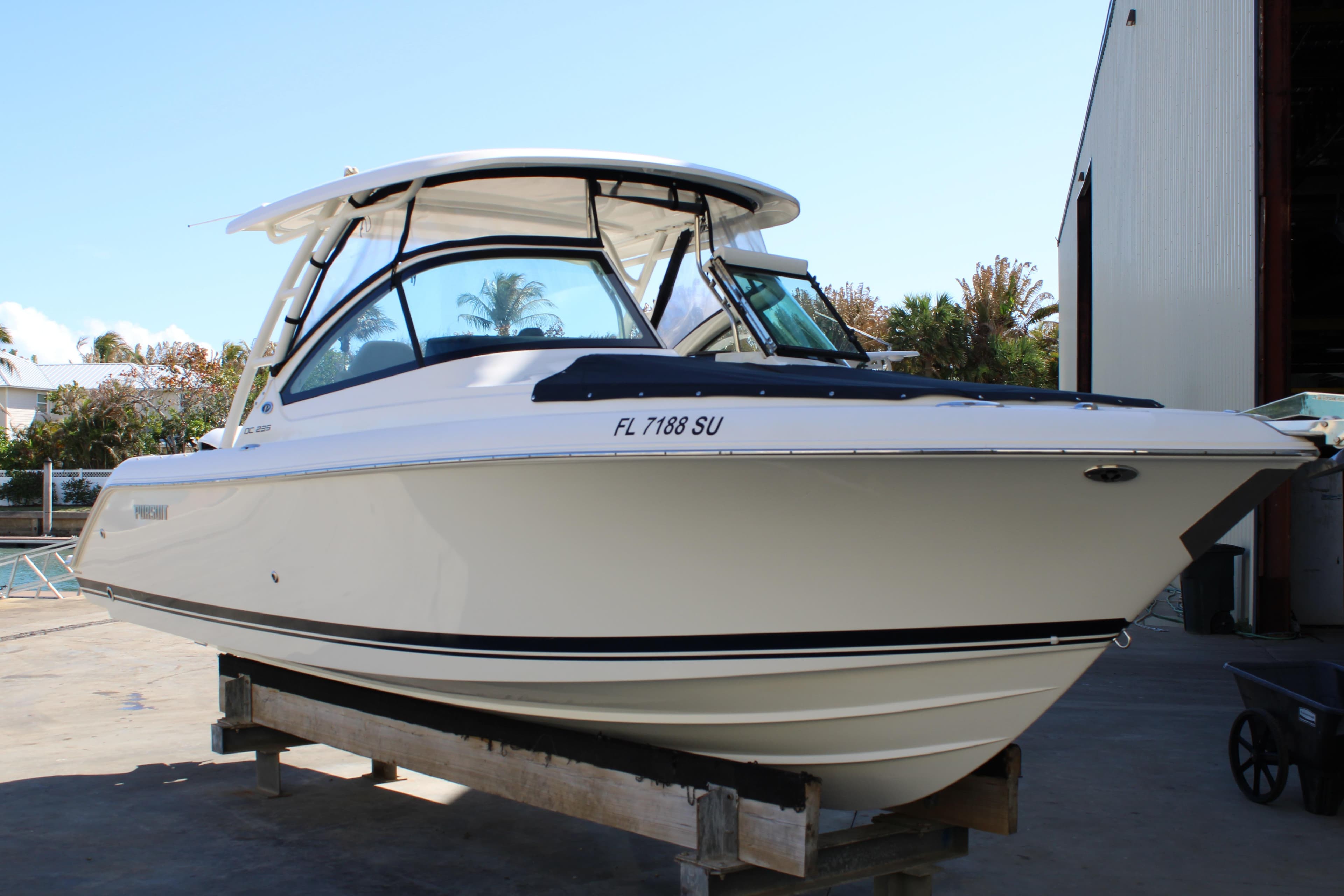 2020 Pursuit DC 235 Dual Console boat on display at a marina.