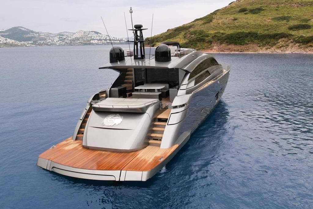 Luxury 2012 Pershing 92 yacht on serene blue waters near a lush coastline.
