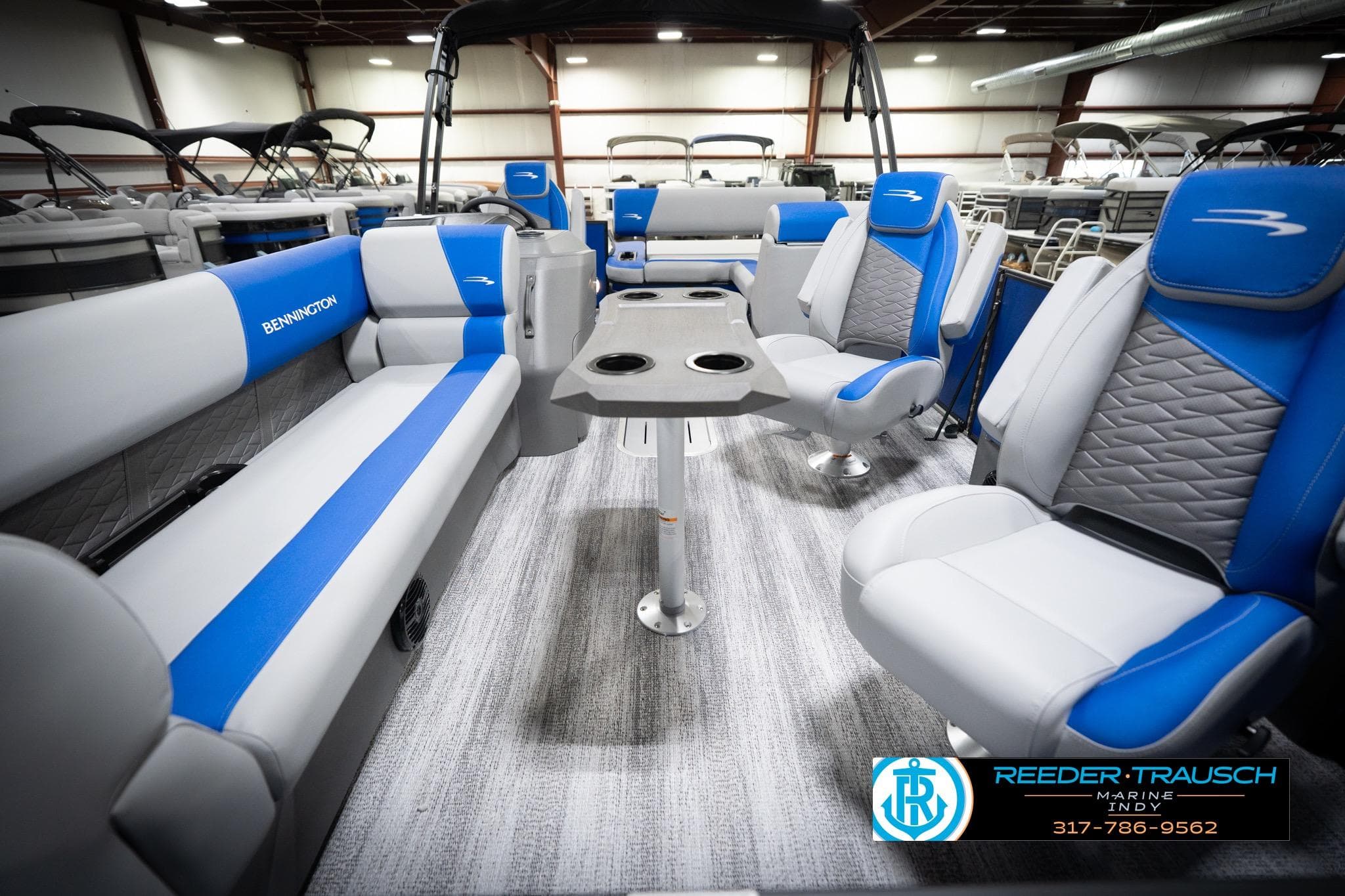 2026 Bennington 22 SSB pontoon boat interior with blue and gray seating, showroom display.