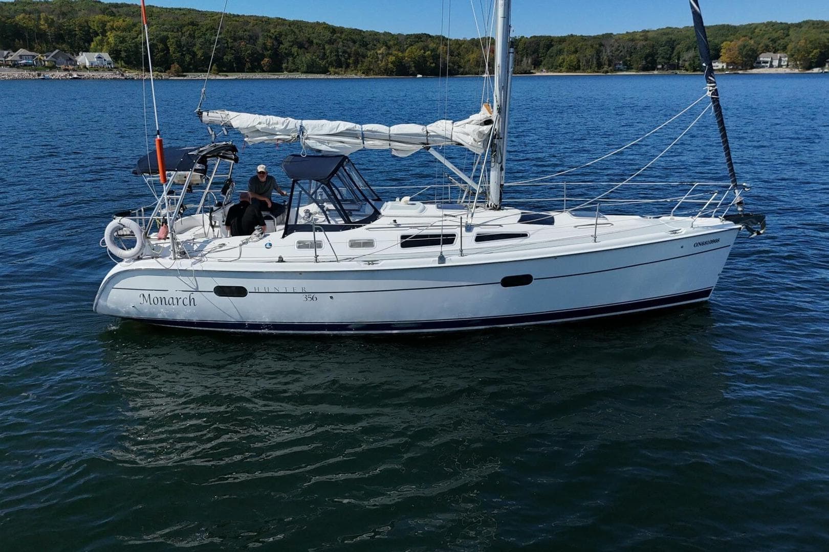Sailing yacht "Monarch," 2003 Hunter 356, cruising on a serene lake.