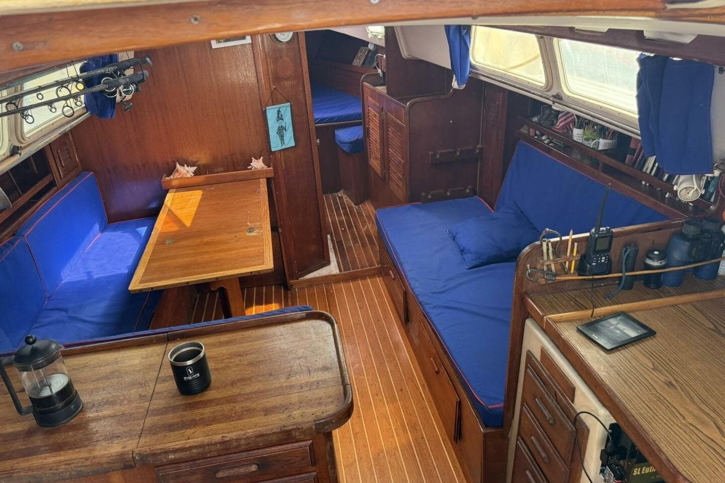 Interior of a 1979 Capital Newport 41S sailboat with blue cushions and wooden furnishings.