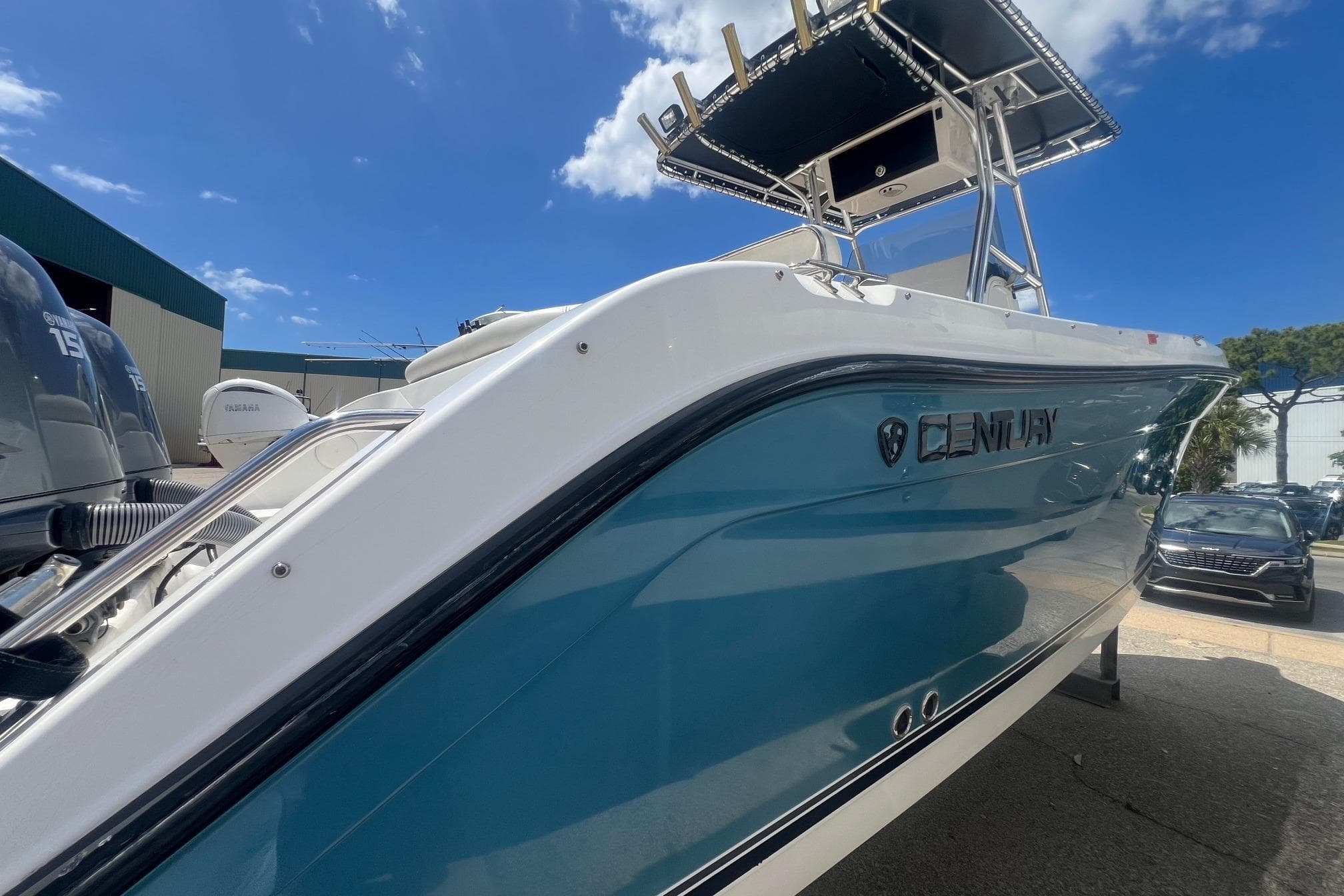 2007 Century 2400 Center Console boat with blue hull, parked outdoors under a clear sky.
