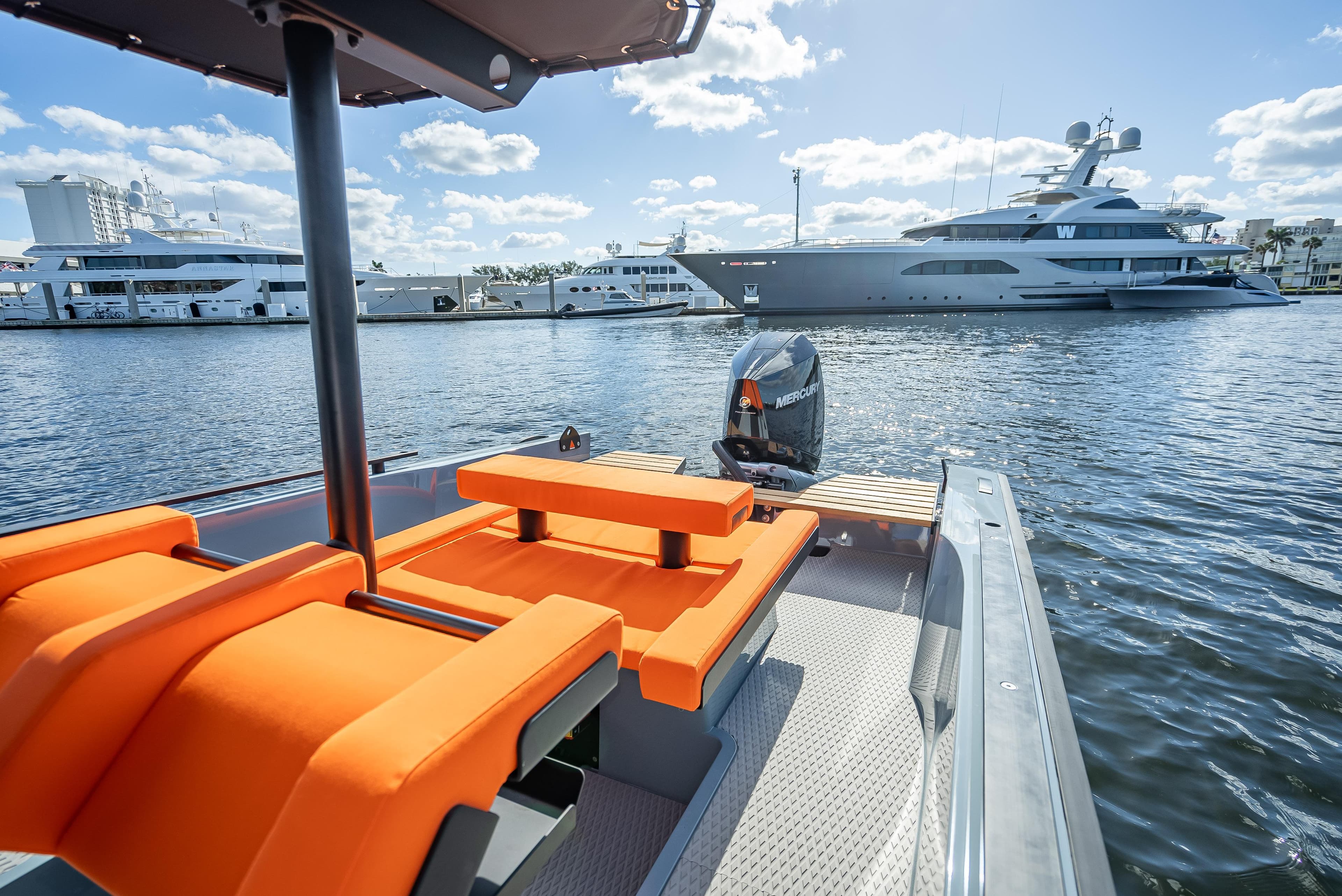 2024 Goldfish 28 Tender boat with orange seats docked in a marina.