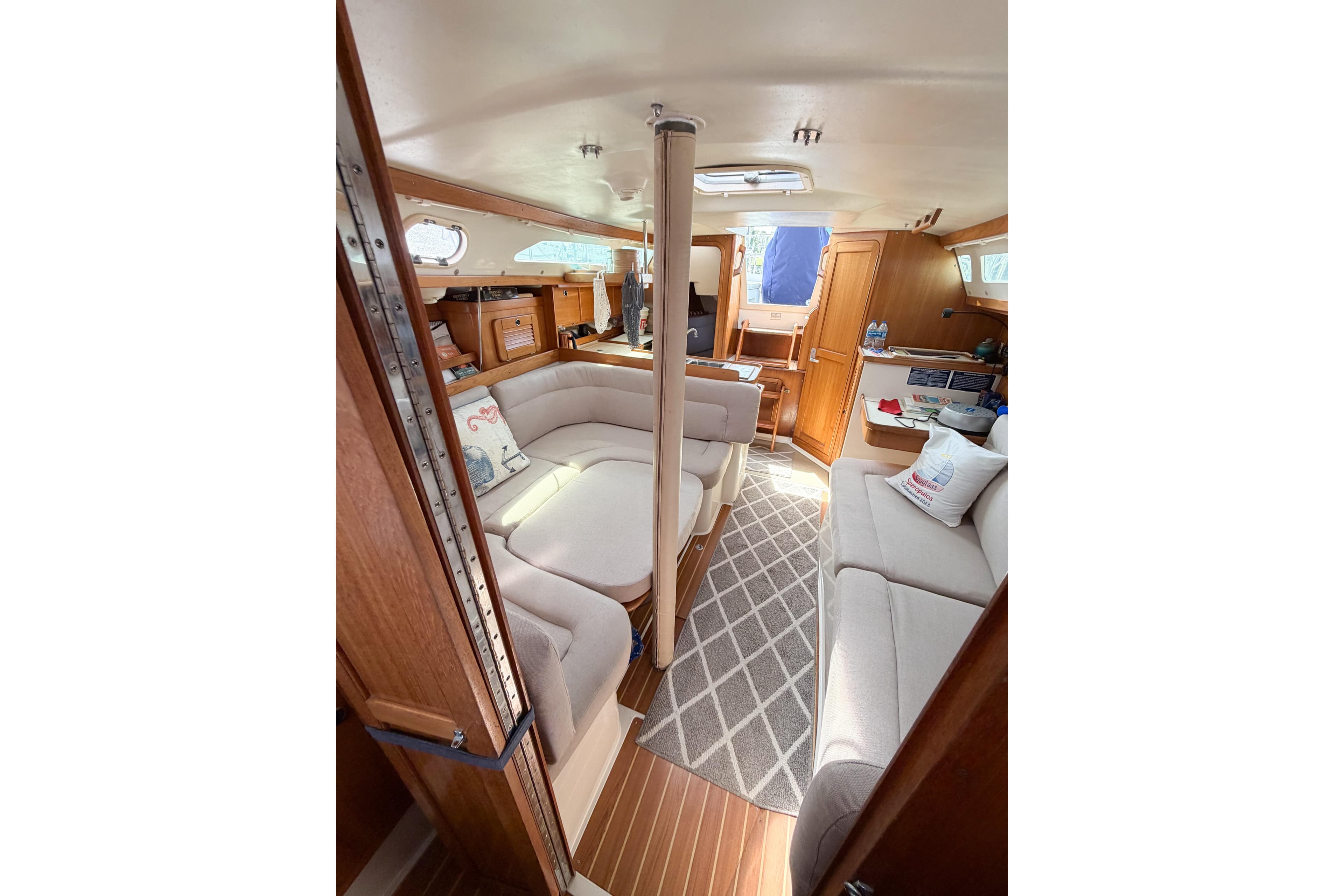 Interior of 2003 Catalina 34 MkII sailboat with cozy seating and wooden finishes.