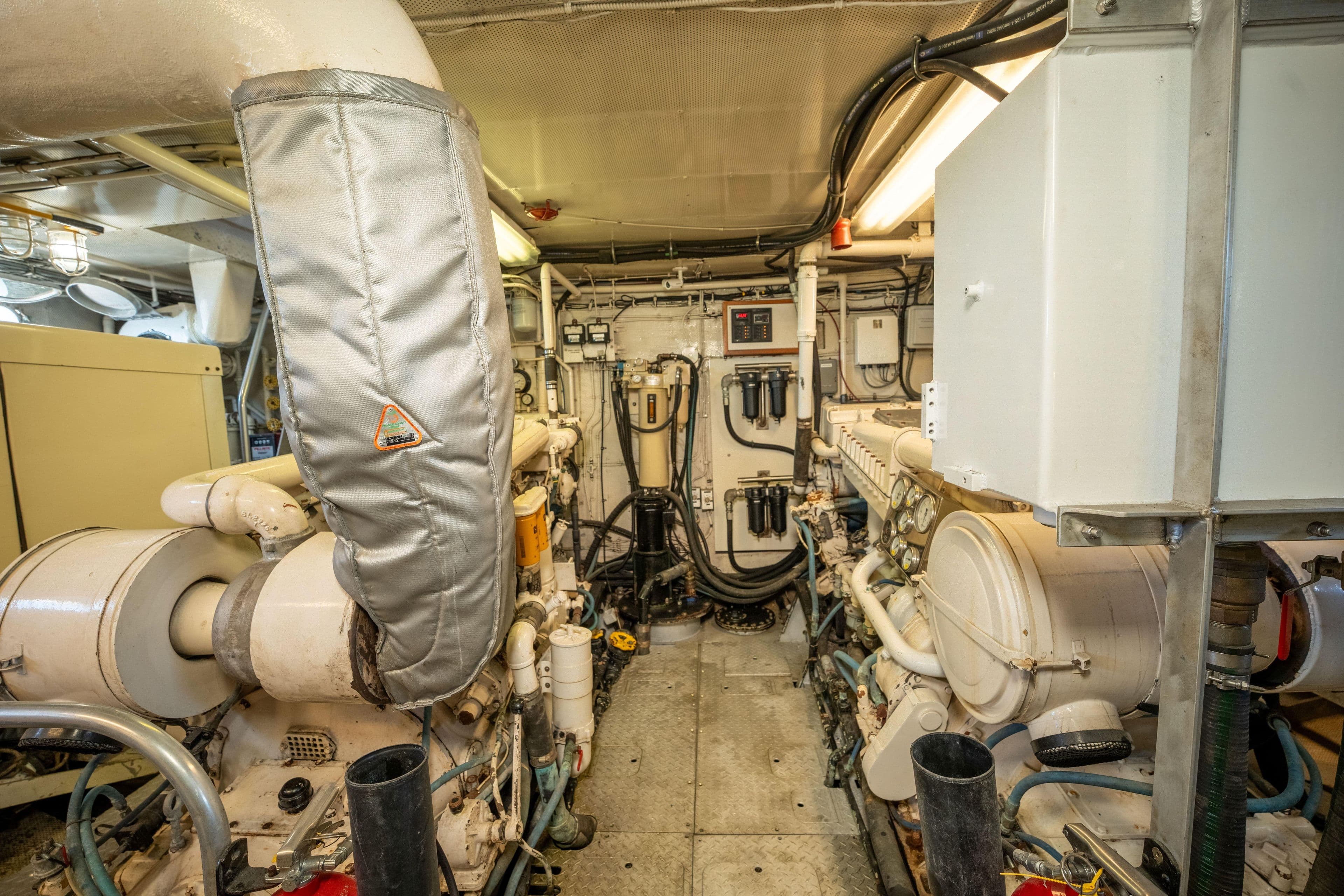 Engine room of a 1969 Custom Hargrave yacht, featuring complex machinery and piping.