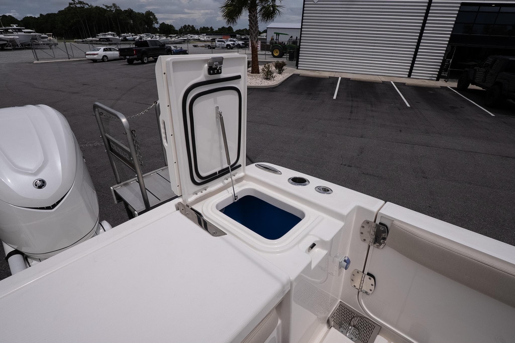 2026 Solace 30 CS boat with open storage compartment in a parking lot.