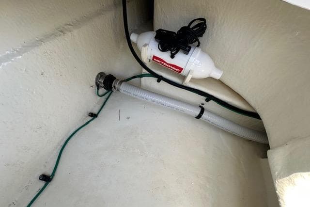 2023 Chaparral 270 OSX boat interior showing a bilge pump and hose setup.