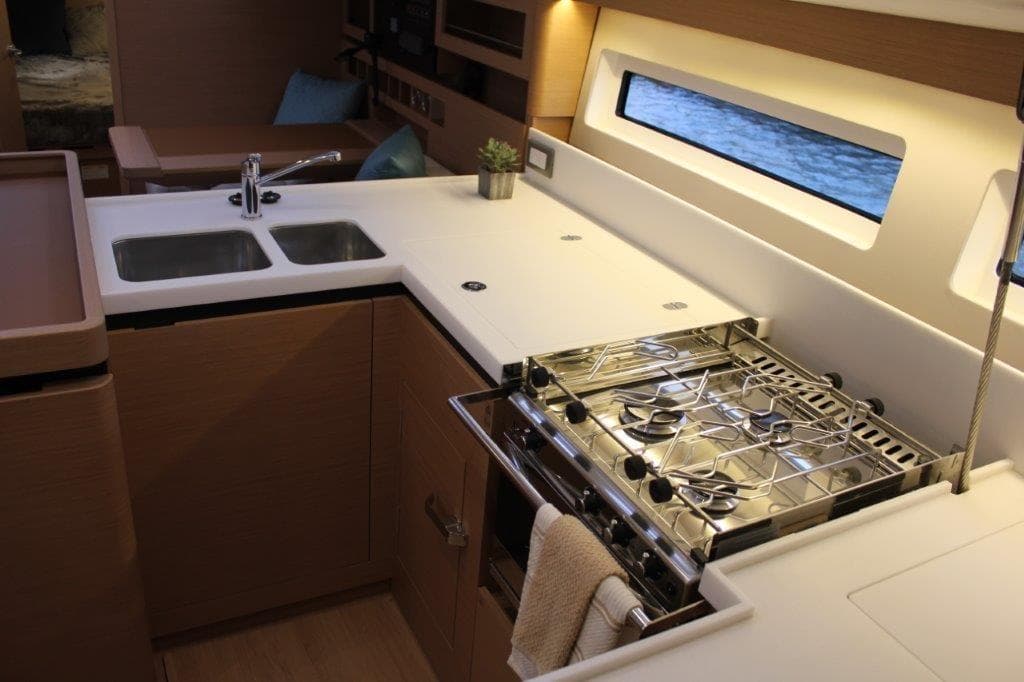 Modern kitchen in 2024 Jeanneau Sun Odyssey 490 yacht with stove and sink.