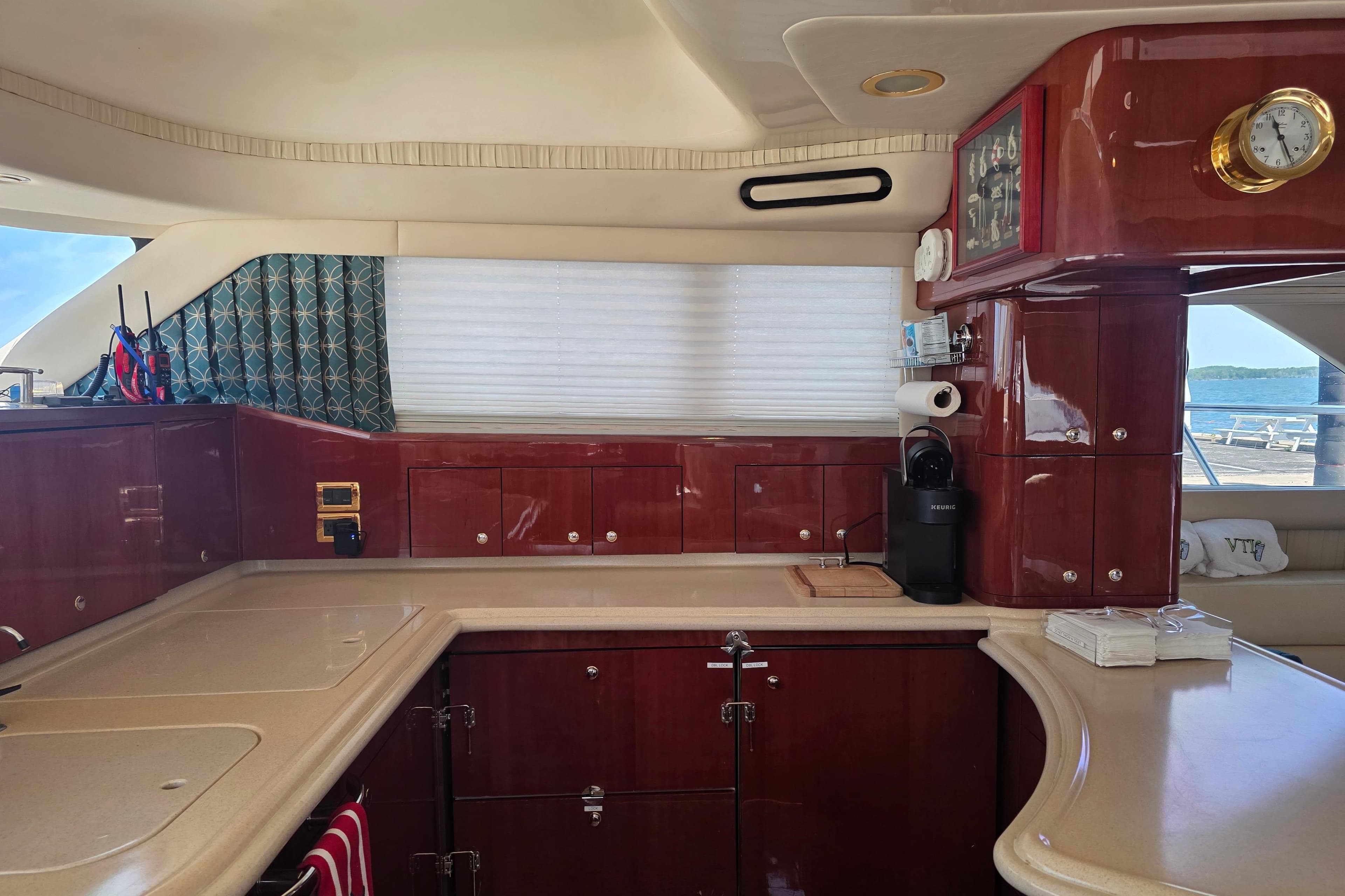 Luxurious kitchen interior of 2002 Sea Ray 560 Sedan Bridge yacht with polished wood cabinetry.