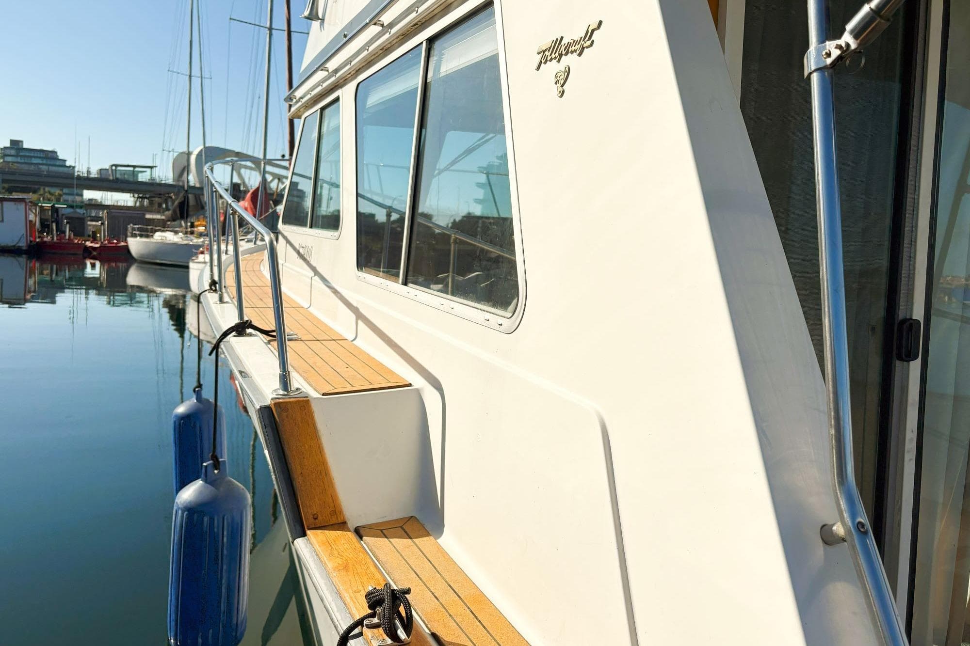 1980 Tollycraft 34 Sedan yacht docked at marina, showcasing sleek design and wooden deck.