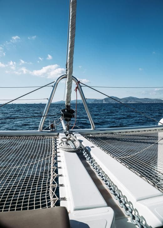 2013 Lagoon 52 catamaran sailing on open sea with clear blue skies.