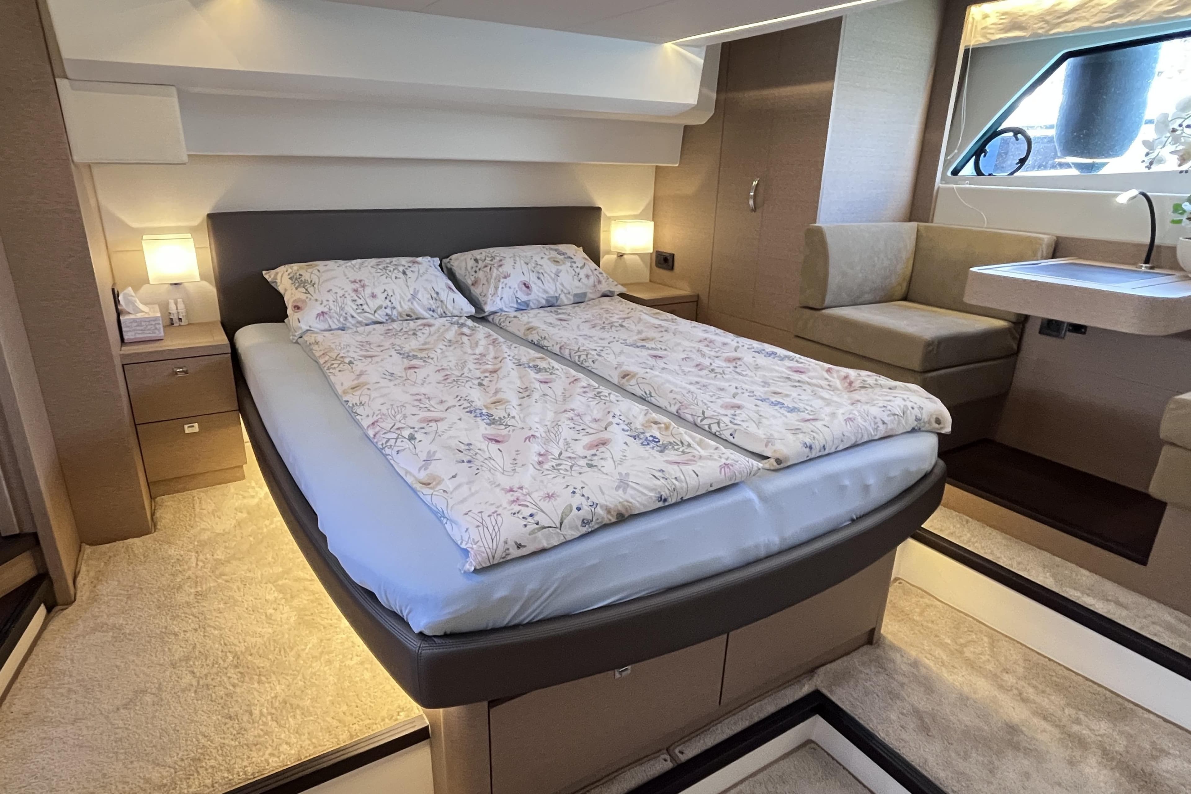 Luxurious 2018 Prestige 500 yacht bedroom with elegant bedding and cozy seating area.