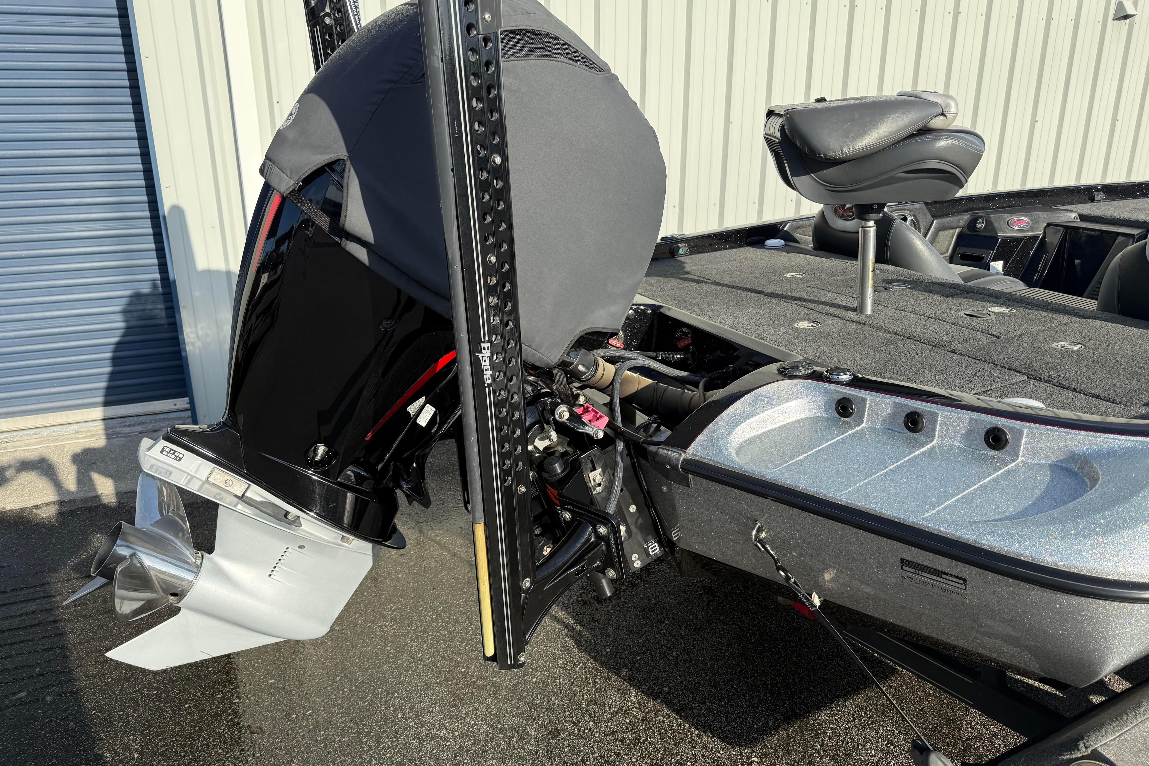 2015 Ranger Z118 Comanche boat with covered outboard motor and seating, parked outdoors.