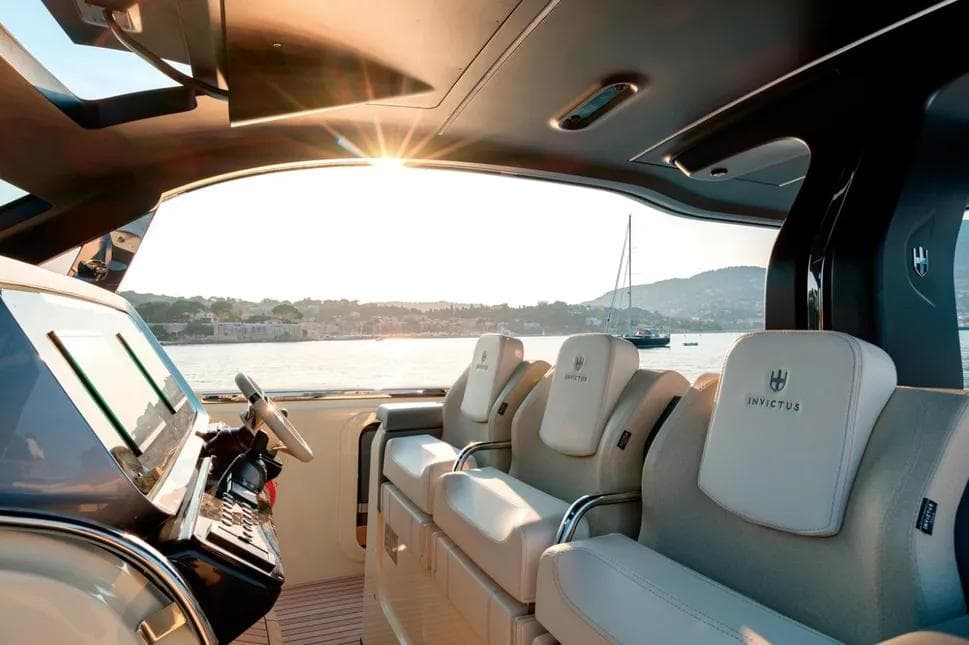 Interior of 2023 Invictus TT460 yacht with luxurious seating and scenic ocean view.