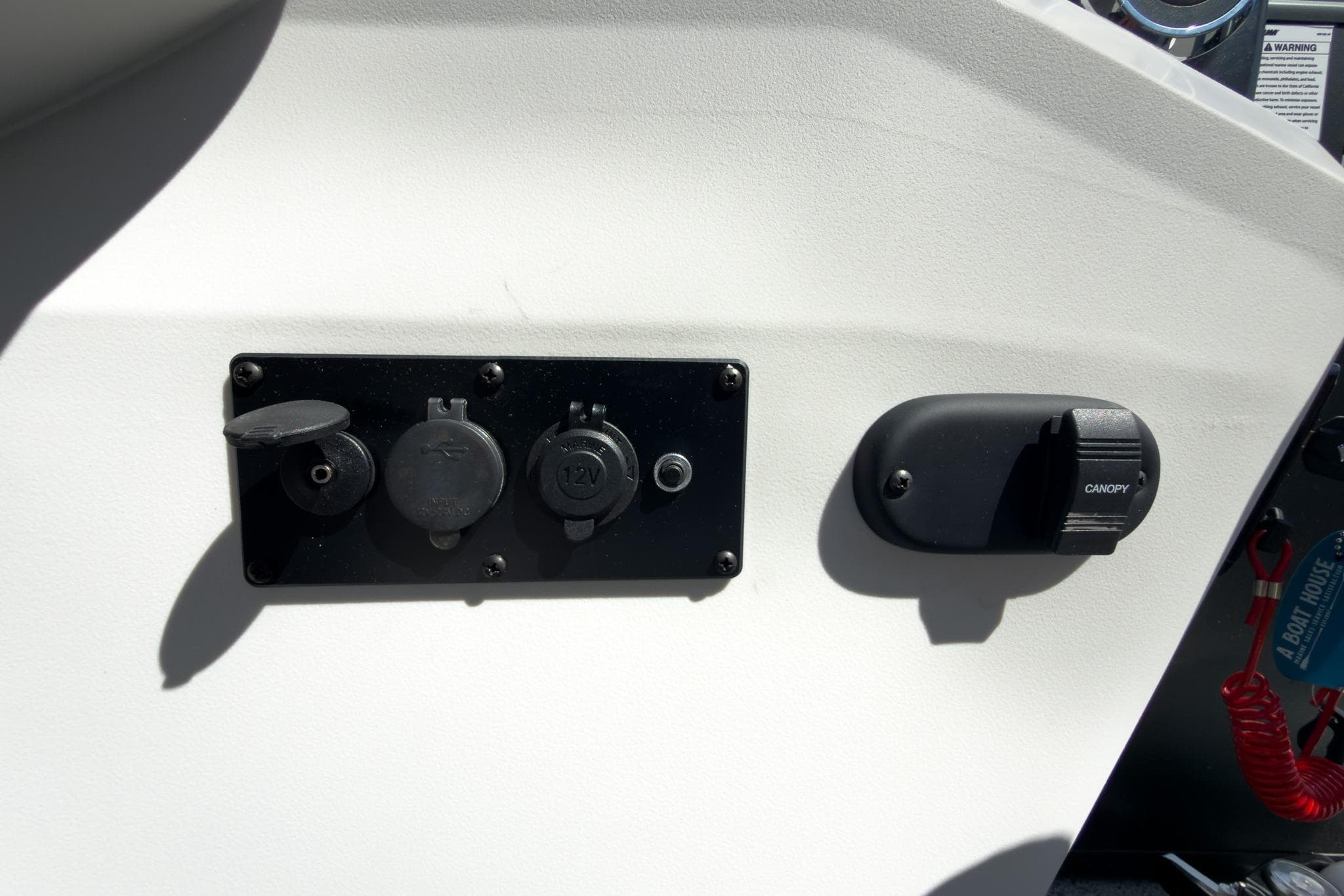 Control panel on 2026 Godfrey Sweetwater 22' Tritoon boat, featuring power outlets and canopy switch.